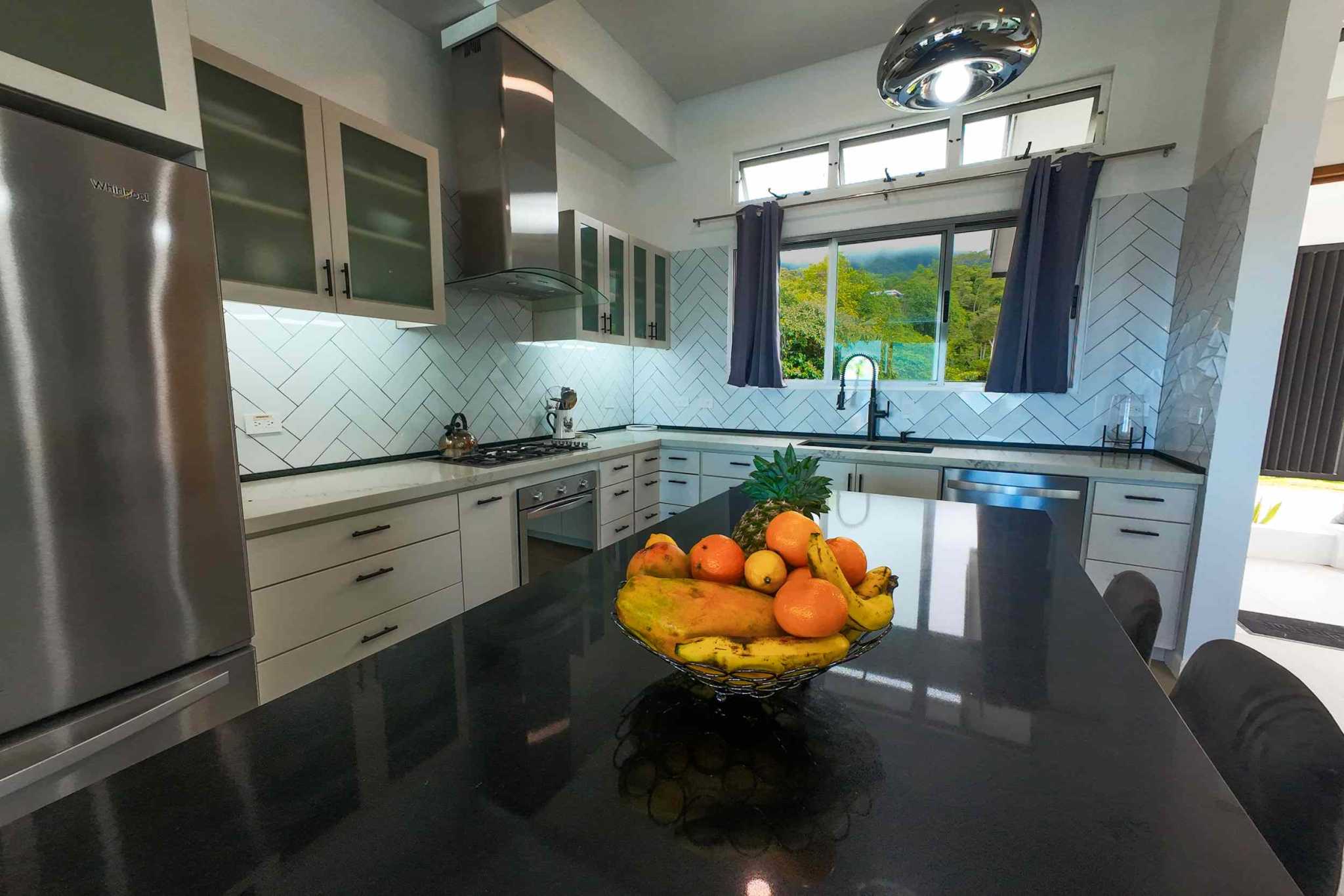 Luxury Retreat kitchen with island, granite counters, and stainless appliances in Ojochal, Costa Rica