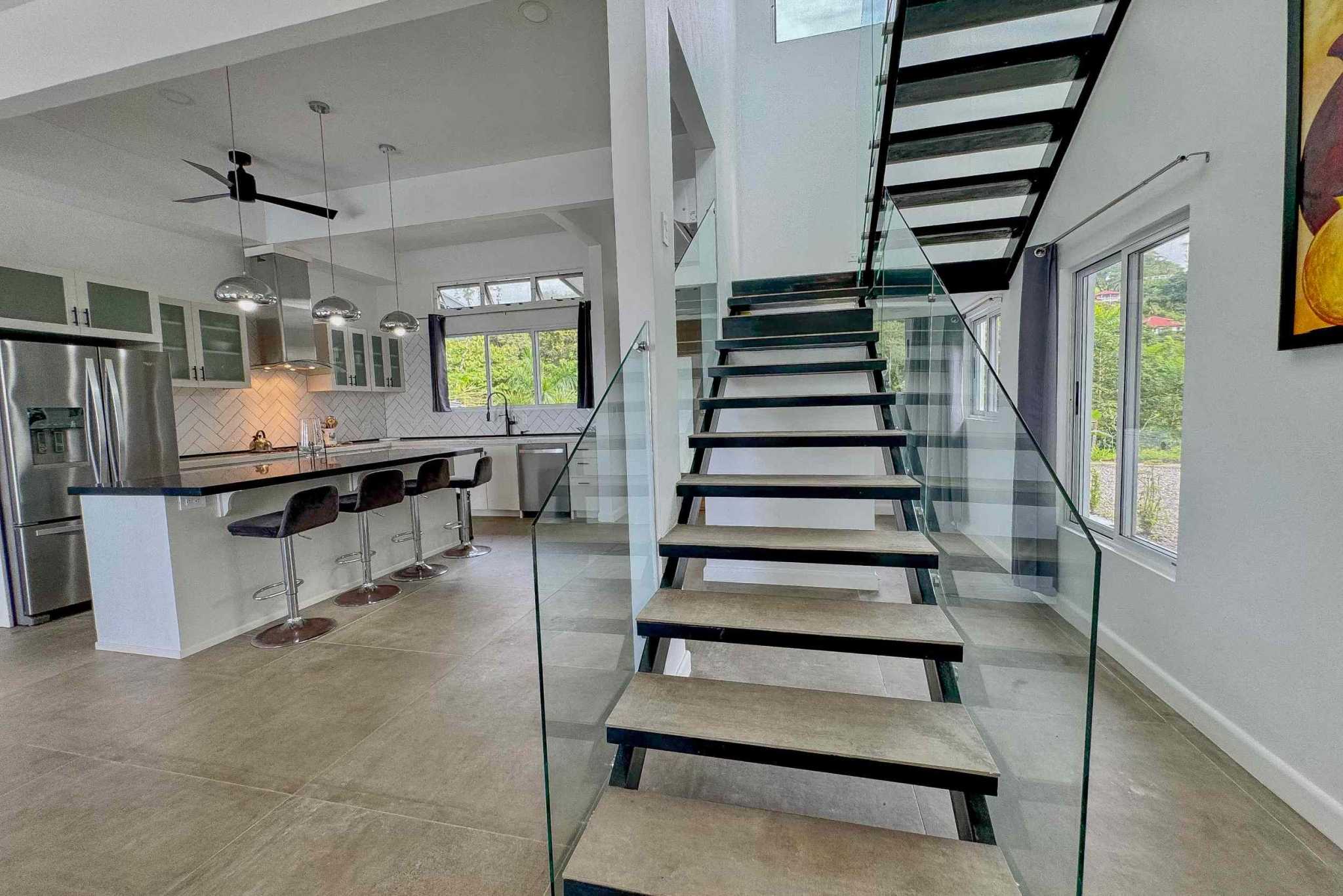 Mountain & Ocean View Home staircase and open kitchen with bar seating in Ojochal, Costa Rica