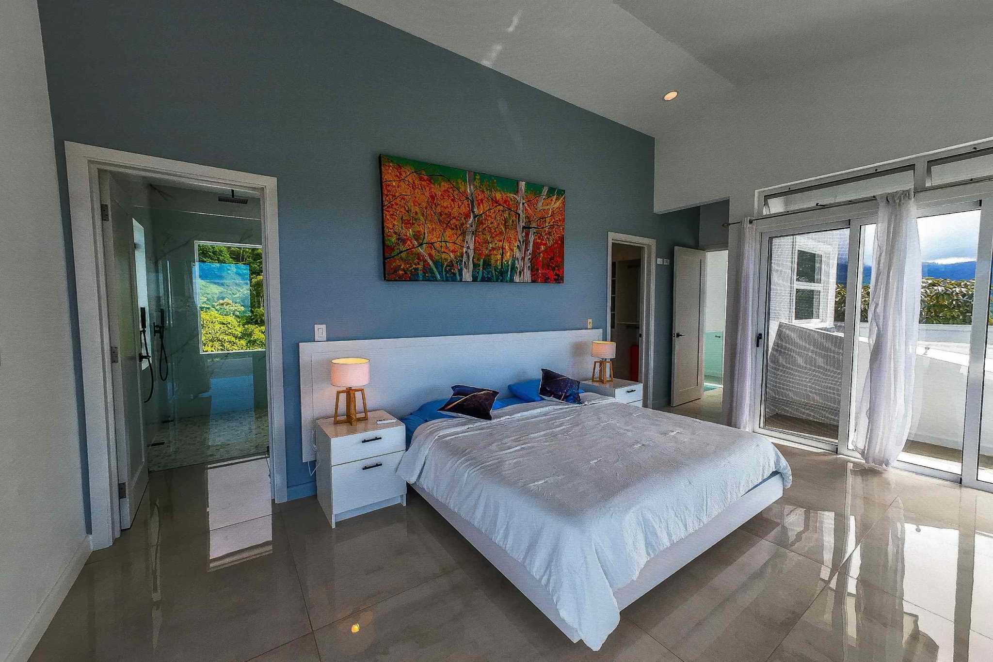 Luxury Mountain Retreat primary bedroom with king bed, artwork, and balcony access in Ojochal, Costa Rica
