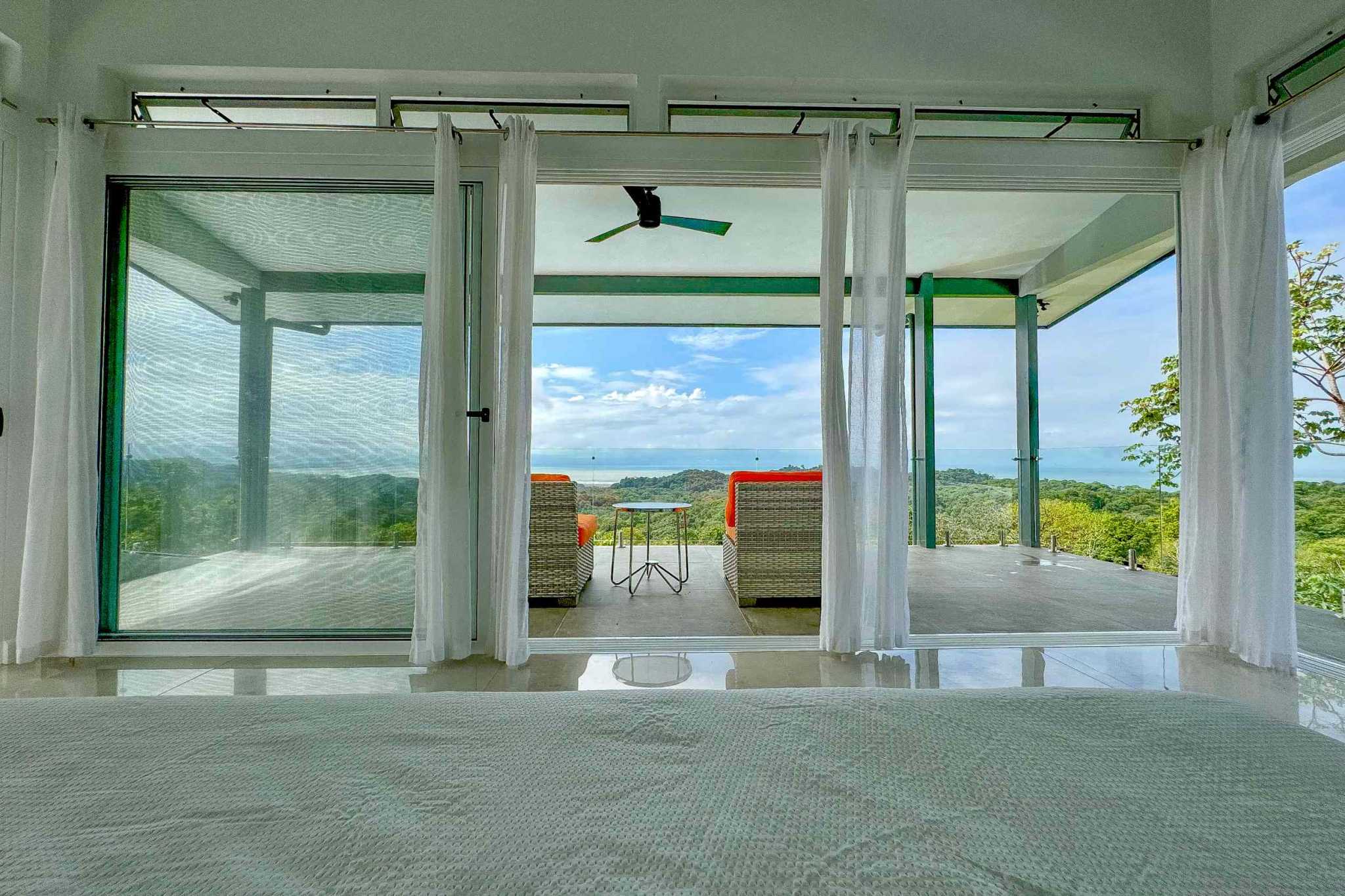 Luxury Retreat bedroom opening to terrace with ocean and mountain views in Ojochal, Costa Rica