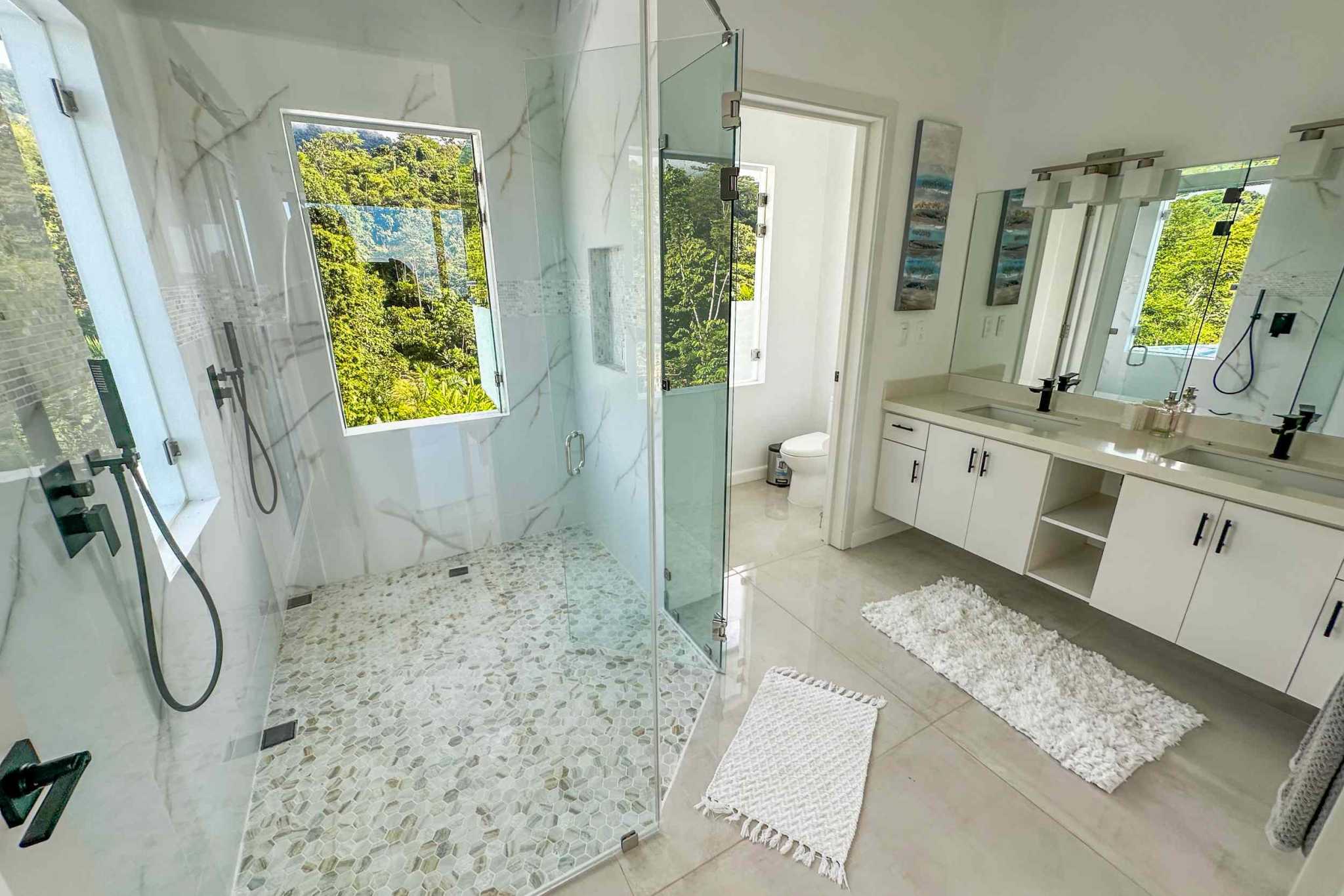 Luxury Mountain Retreat glass walk-in shower and double vanity bathroom with jungle view in Ojochal, Costa Rica