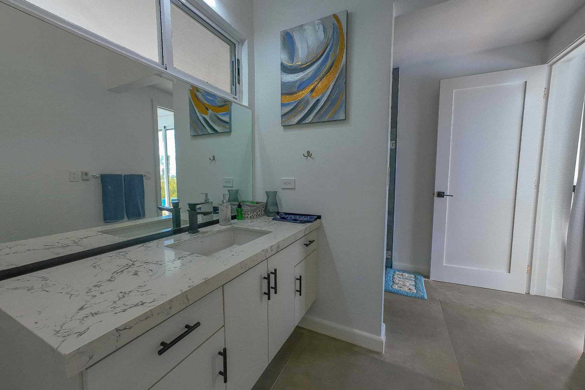 Luxury Ojochal Retreat bathroom vanity with marble countertop and artwork in Ojochal, Costa Rica