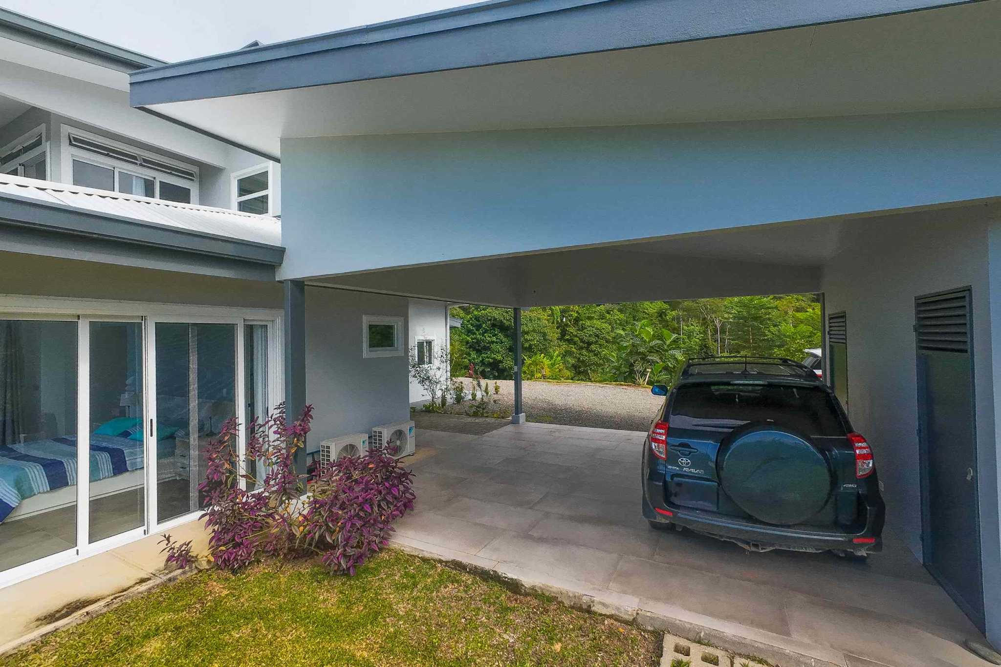 Mountain & ocean view retreat carport with SUV and adjoining open bedroom in Ojochal, Costa Rica