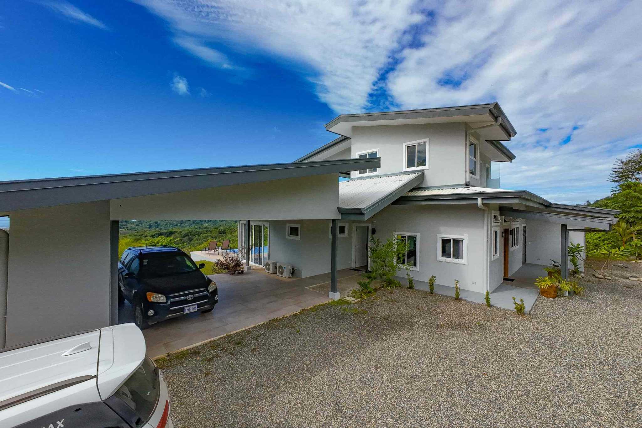 Luxury Mountain Retreat with modern two-story exterior, carport, and mountain views in Ojochal, Costa Rica