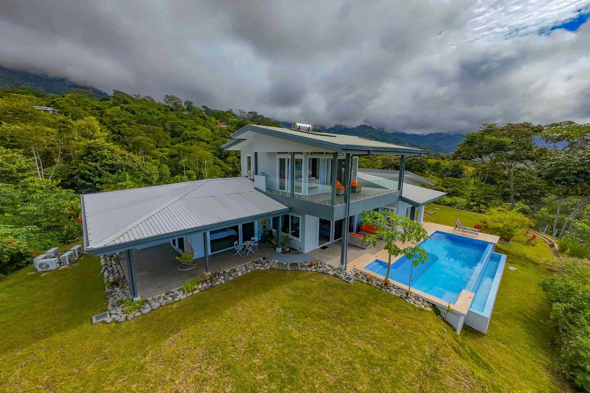 Mountain retreat home aerial view with infinity pool and lush greenery in Ojochal, Costa Rica