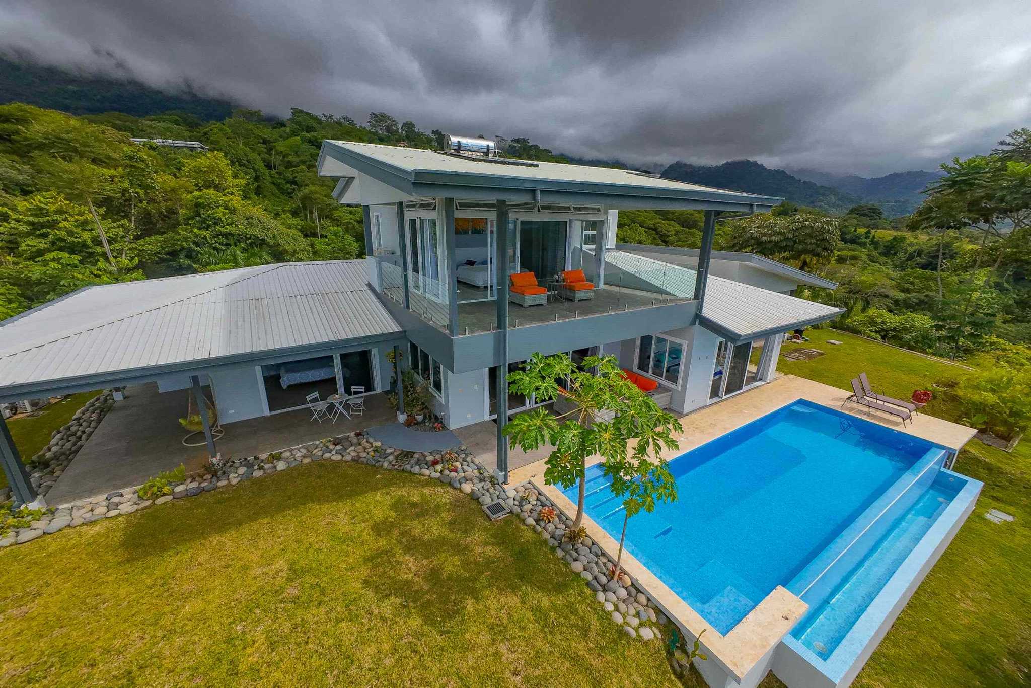 Mountain Retreat Villa aerial view of home with infinity pool and mountain backdrop in Ojochal, Costa Rica