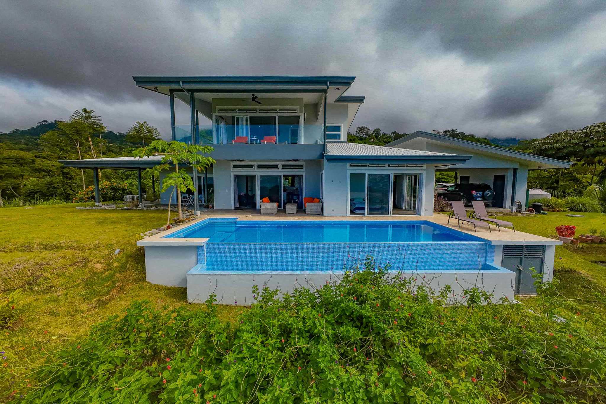 Luxury Retreat elevated pool and two-story villa exterior with jungle surroundings in Ojochal, Costa Rica