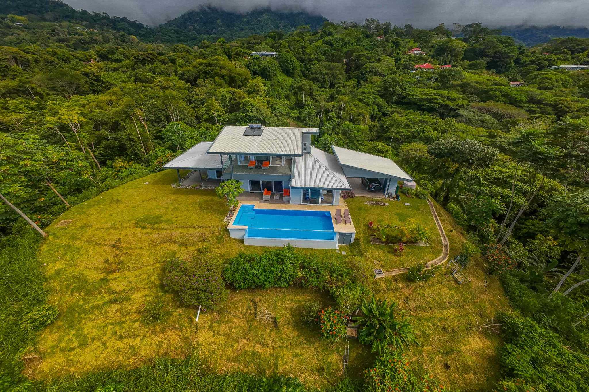 Mountain & Ocean View Luxury Retreat aerial view of home with pool and rainforest surroundings in Ojochal, Costa Rica