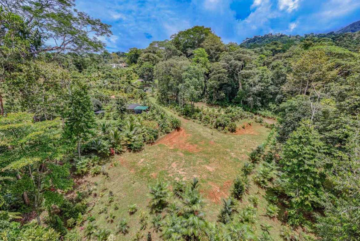Tropical Home aerial view of cleared grassy lot surrounded by dense rainforest in Ojochal, Costa Rica