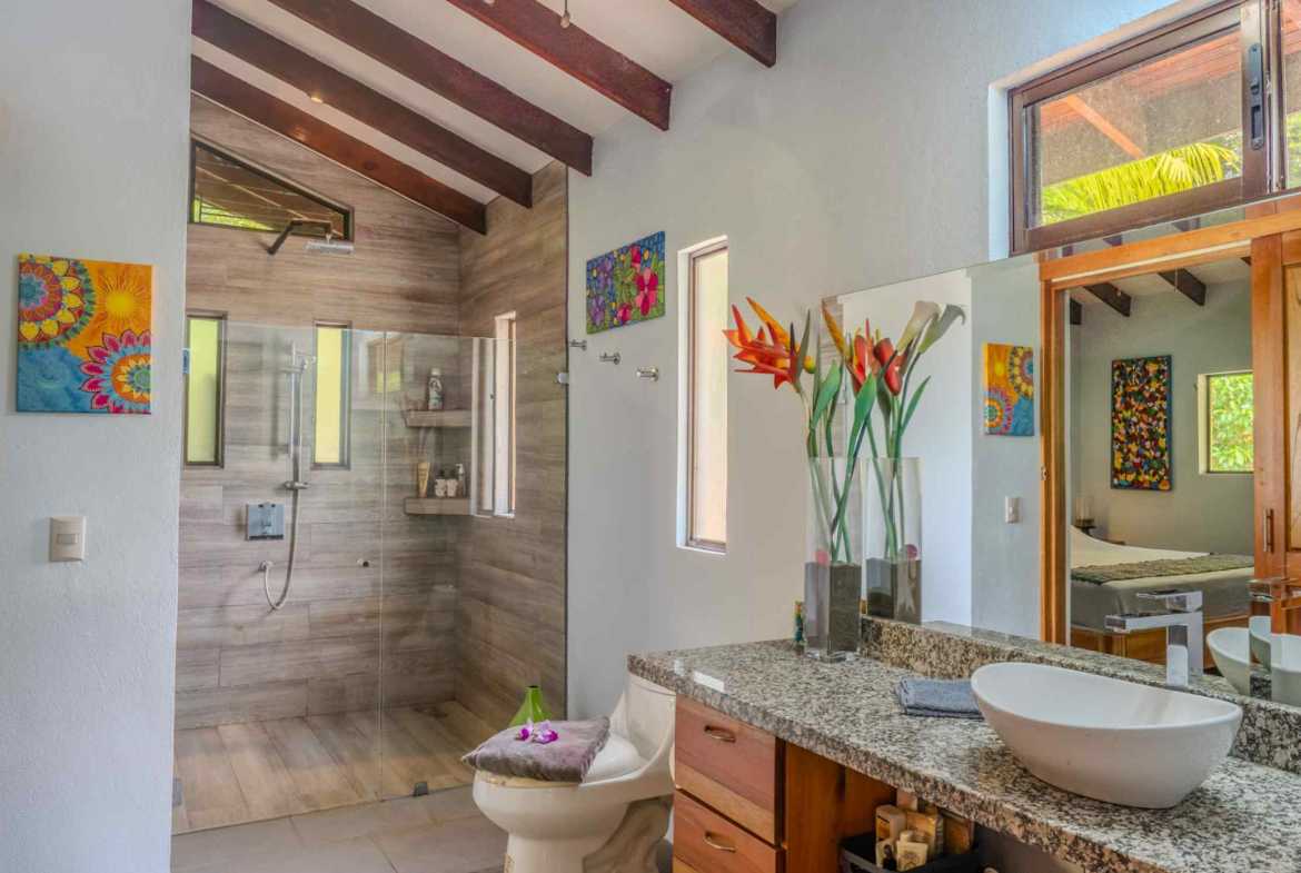 Costa Rica home bathroom with glass walk-in shower and granite vessel sink vanity in Ojochal, Costa Rica
