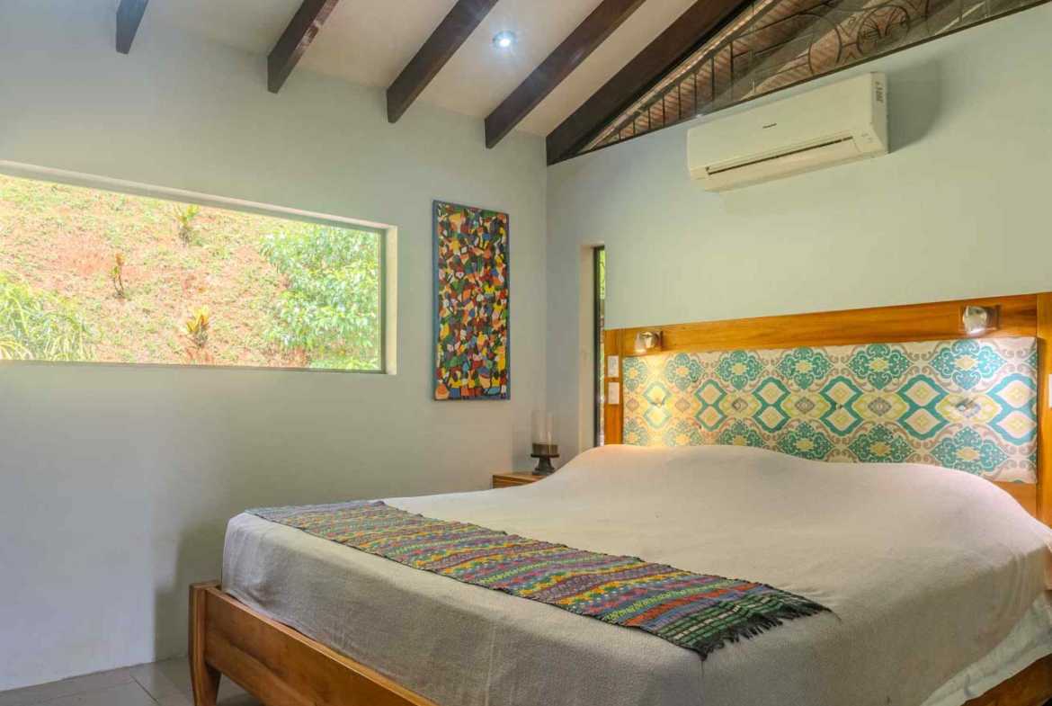 Costa Rica Home with River & Pool: bedroom with wood beams, tiled headboard and garden-view window in Ojochal, Costa Rica