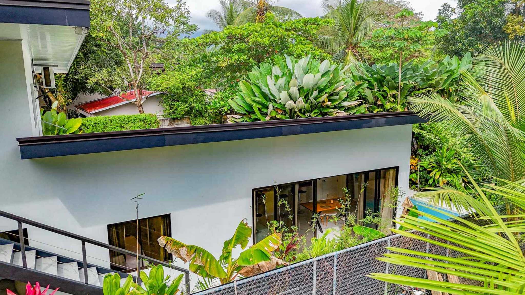 55856-22 3-Bedroom Home with Pool: white modern exterior, glass doors, staircase and lush tropical garden in Bahia, Costa Rica