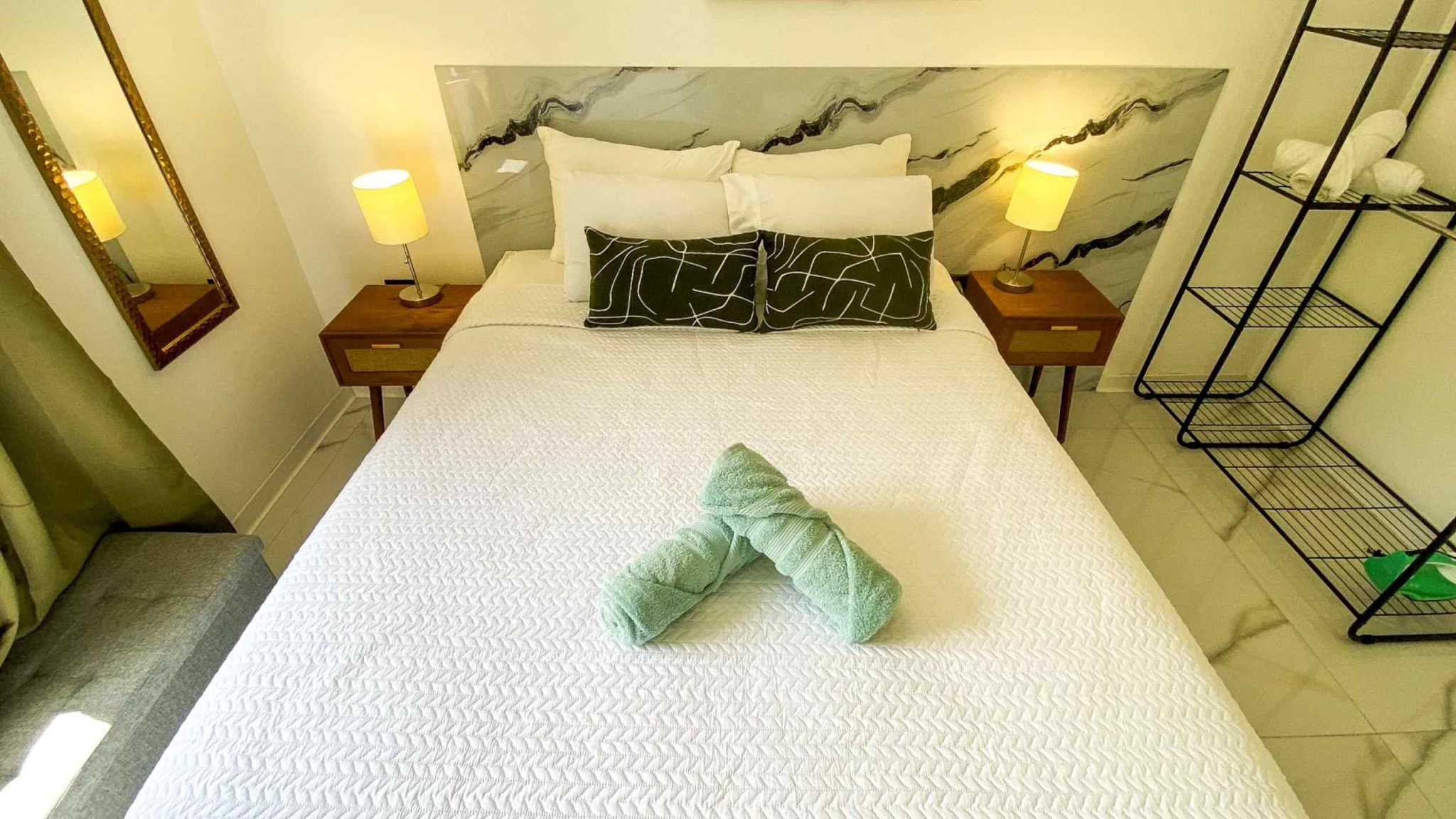 55856-18 Stunning 3-Bedroom Home bedroom with white bedding, marble-look headboard and wooden nightstands in Bahia, Costa Rica