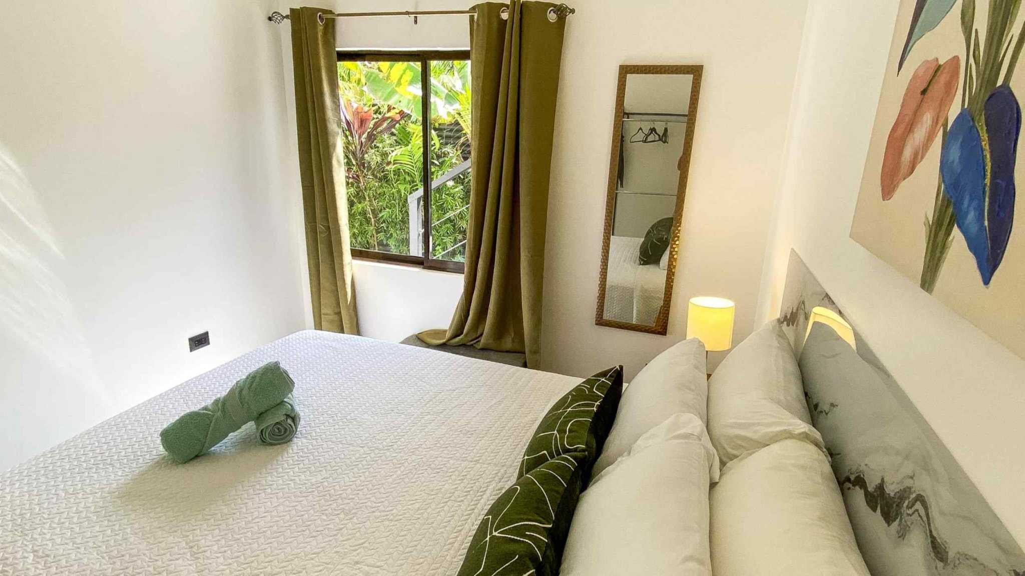 55856-19 Stunning 3-Bedroom Home bedroom with white bed, green accents and tropical garden window view in Bahia, Costa Rica