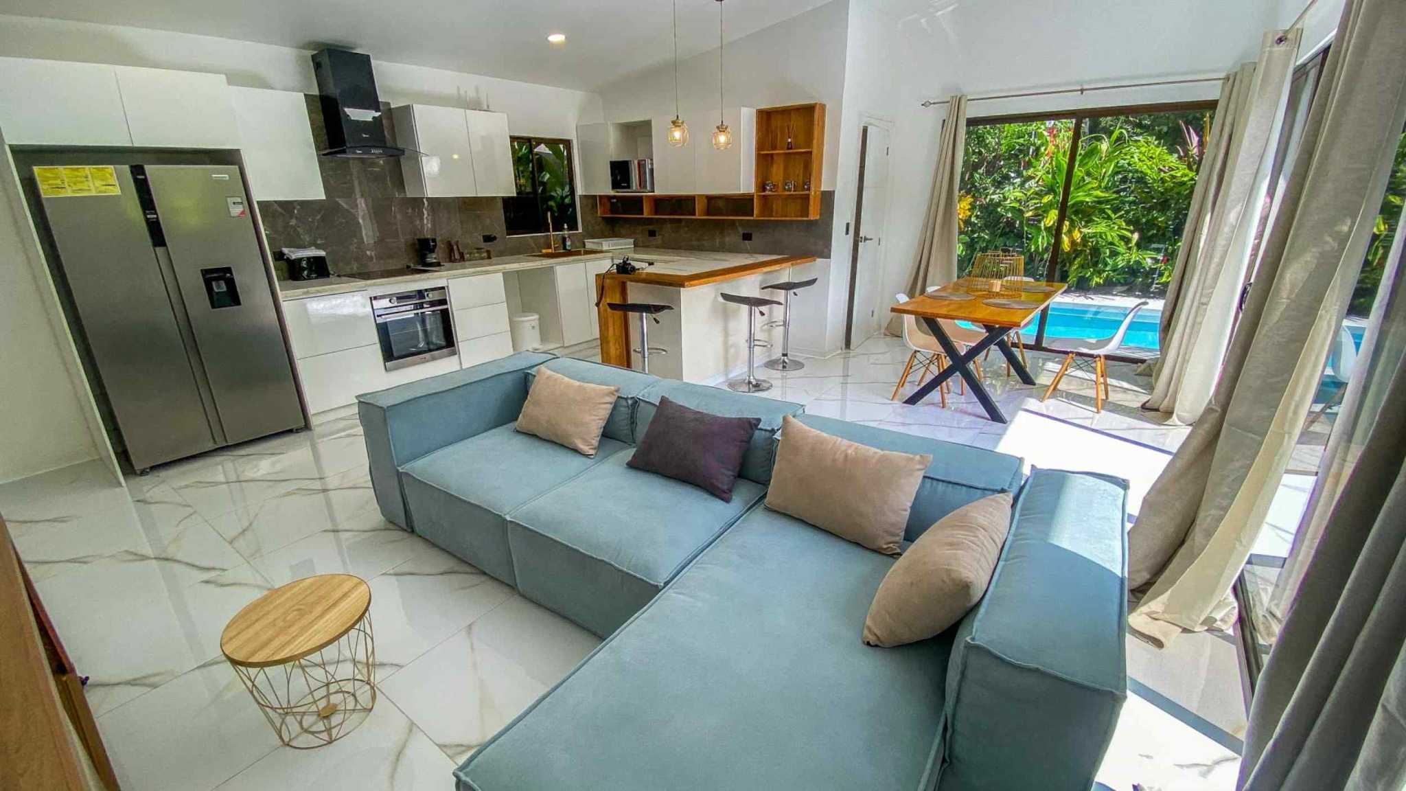 55856-4 3-Bedroom Home with Pool: open-plan living room, kitchen and dining area beside pool doors in Bahia, Costa Rica