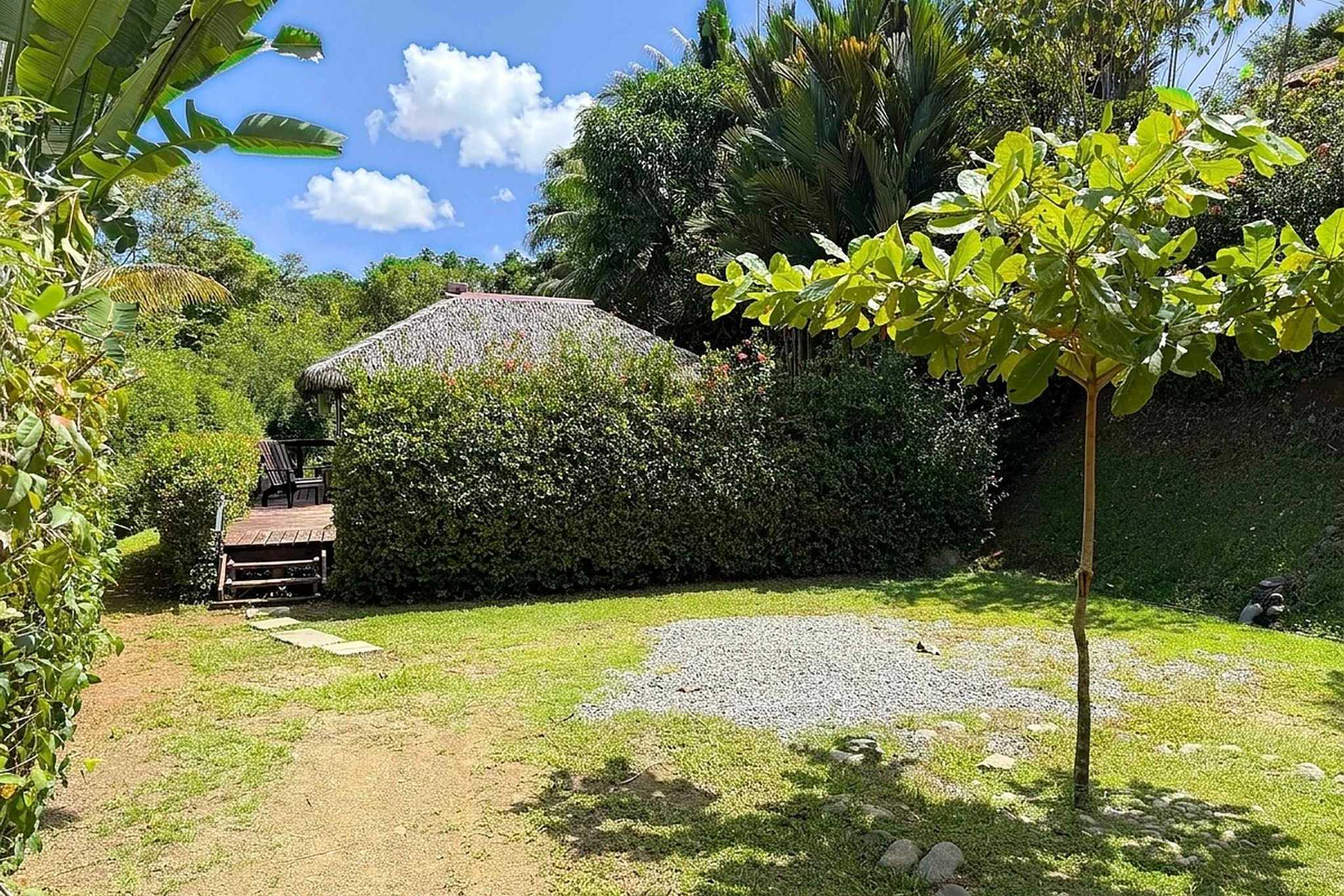 65486-26 Jungle Sanctuary garden path with palapa thatched roof and wooden deck amid tropical plants in Ojochal, Costa Rica