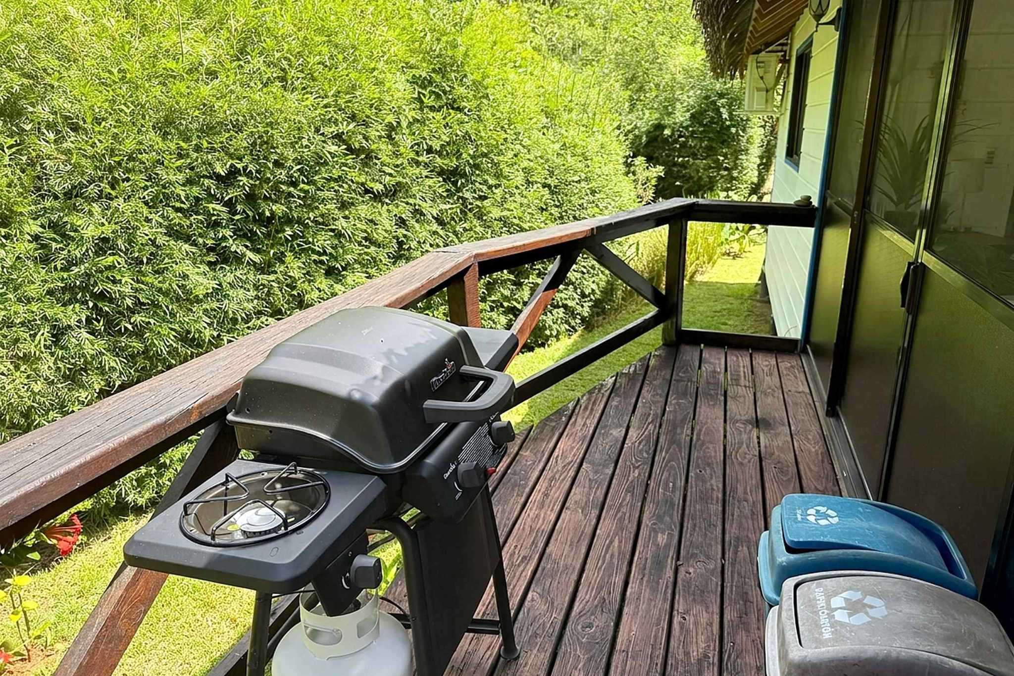 65486-27 Jungle Sanctuary deck with propane grill, recycling bins, and lush greenery in Ojochal, Costa Rica