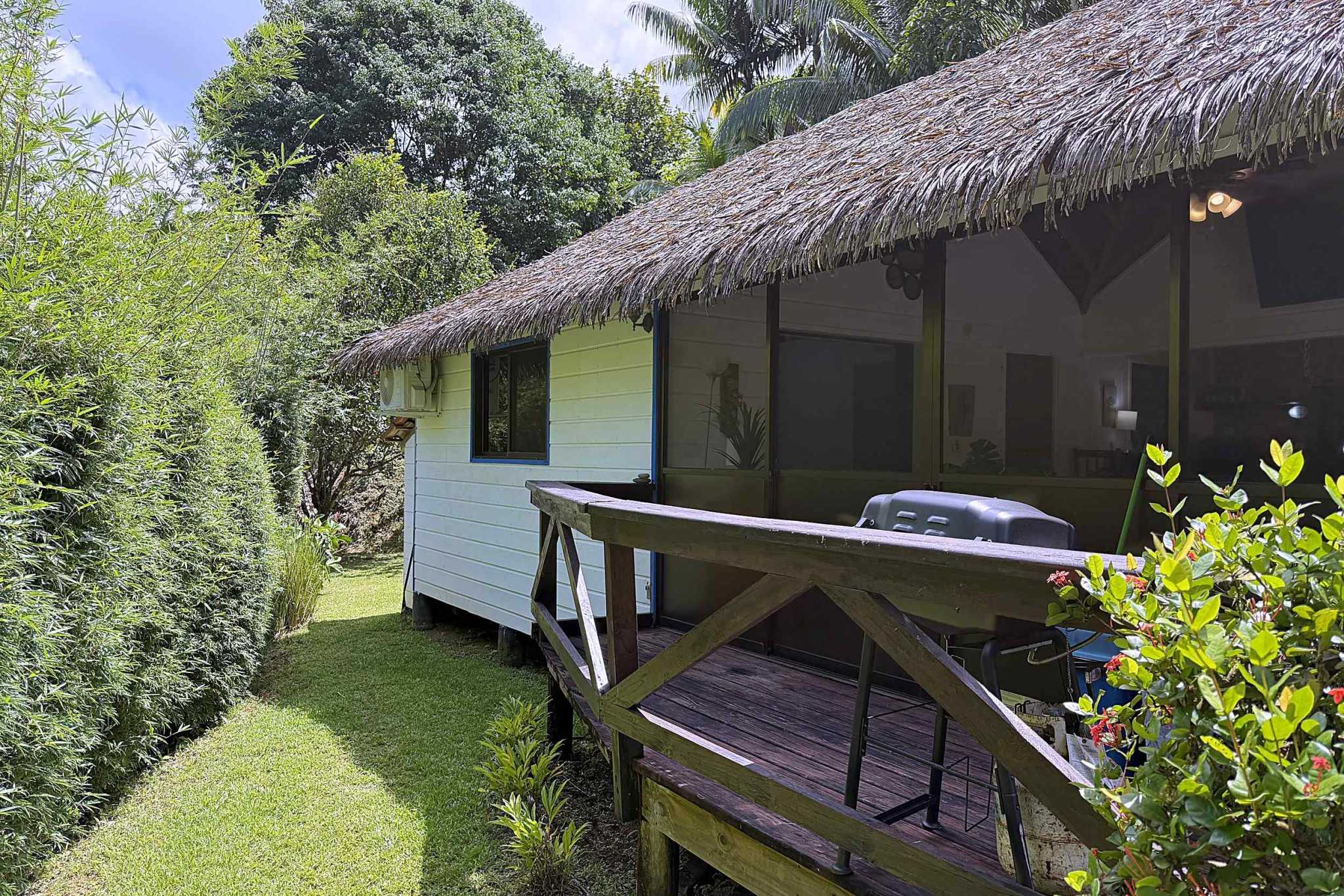65486-28 Jungle Sanctuary cabin exterior with thatched roof and wooden deck amid bamboo in Ojochal, Costa Rica