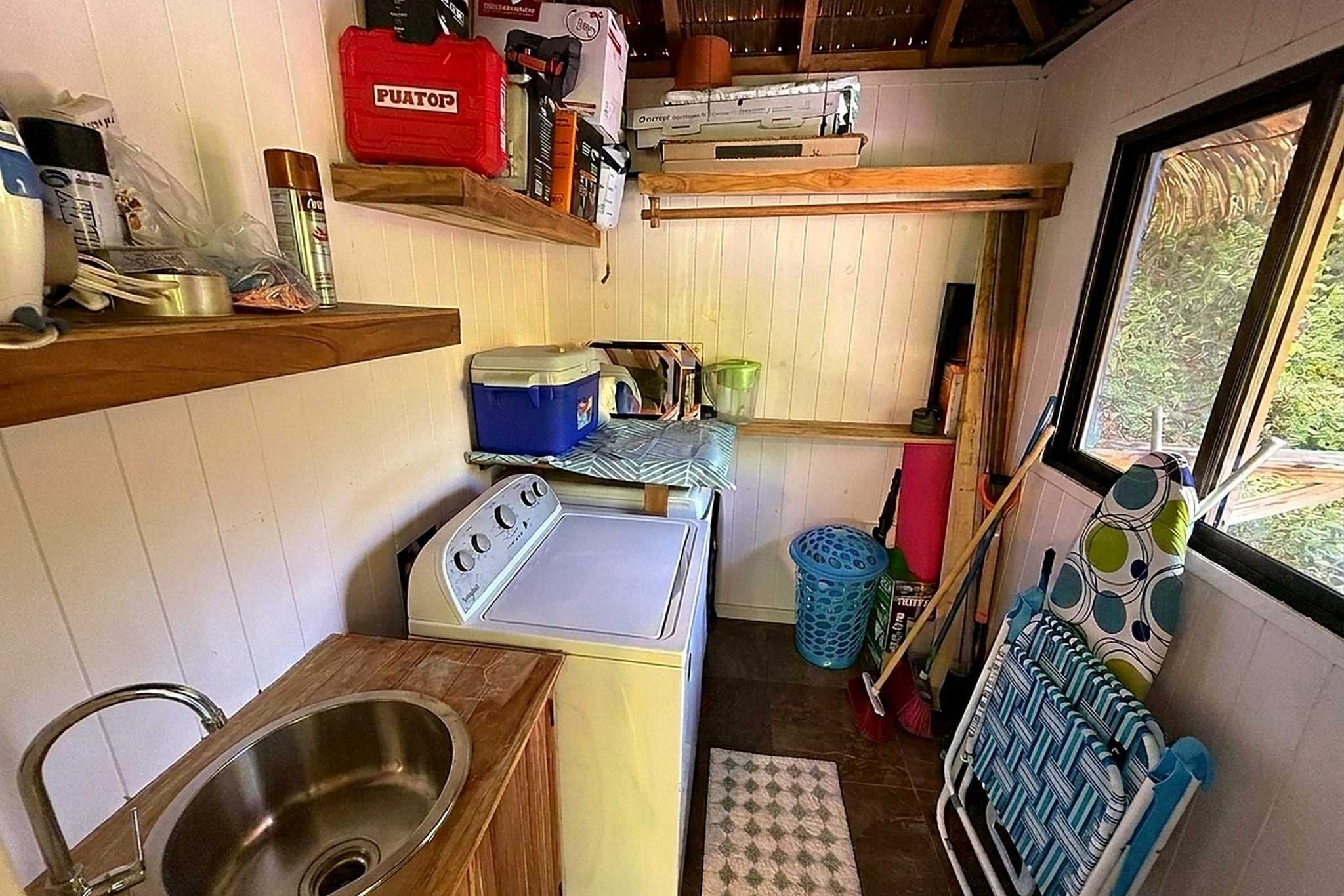 65486-31 Jungle Sanctuary utility room with washer, sink, and storage shelves in Ojochal, Costa Rica