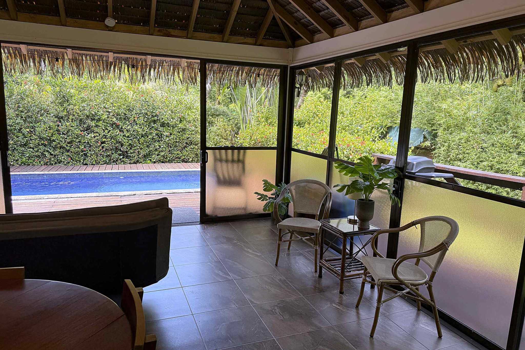 65486-07 Jungle Sanctuary screened palapa lounge with rattan chairs and pool view in Ojochal, Costa Rica
