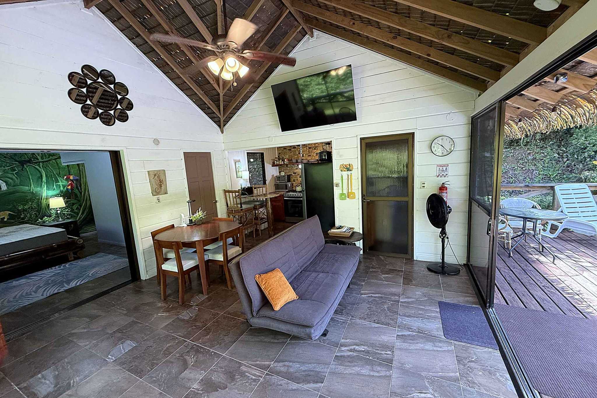 65486-09 Jungle Sanctuary Retreat living and dining area with vaulted wood ceiling and deck access in Ojochal, Costa Rica