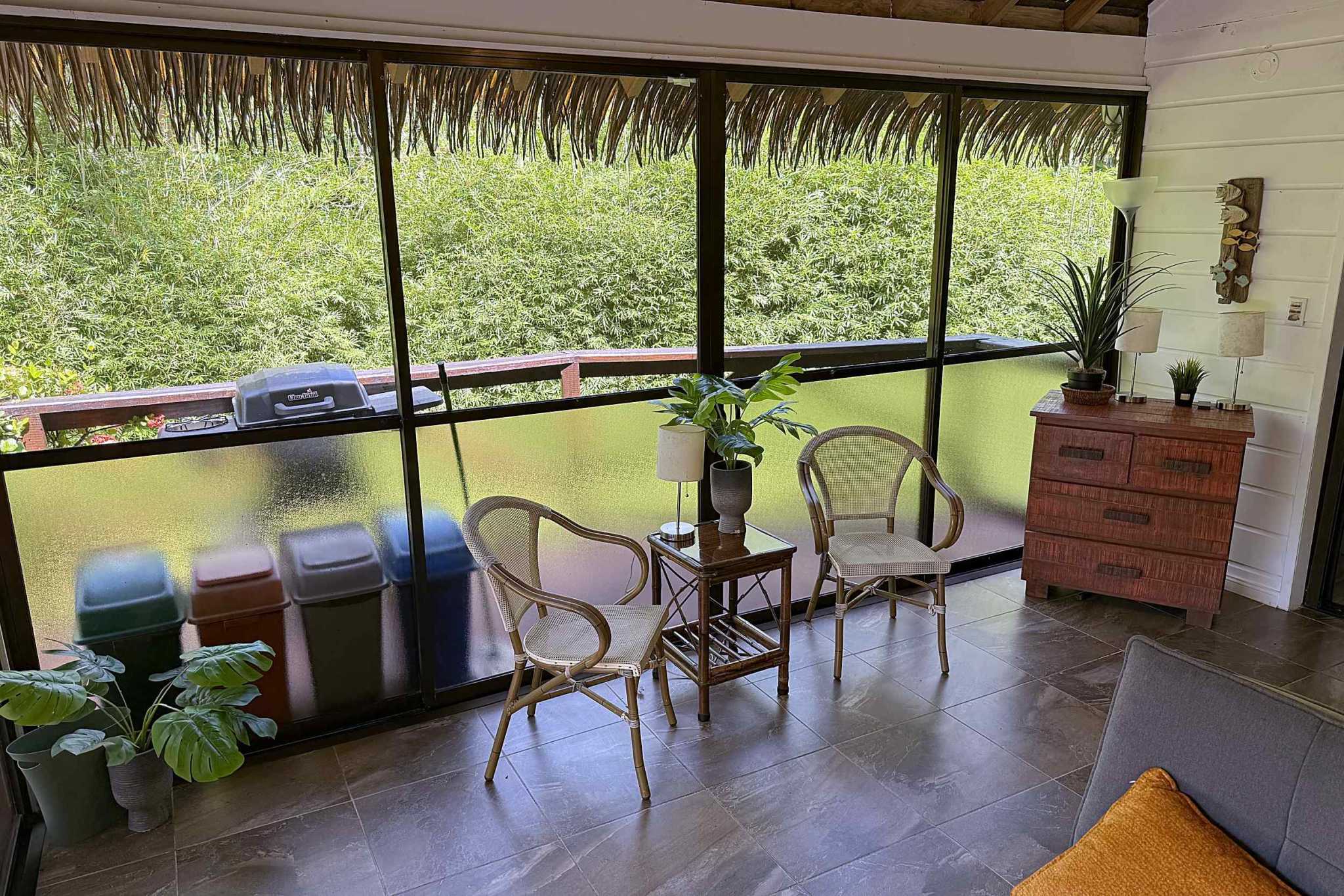 65486-11 Jungle Sanctuary screened balcony with rattan chairs and jungle view in Ojochal, Costa Rica