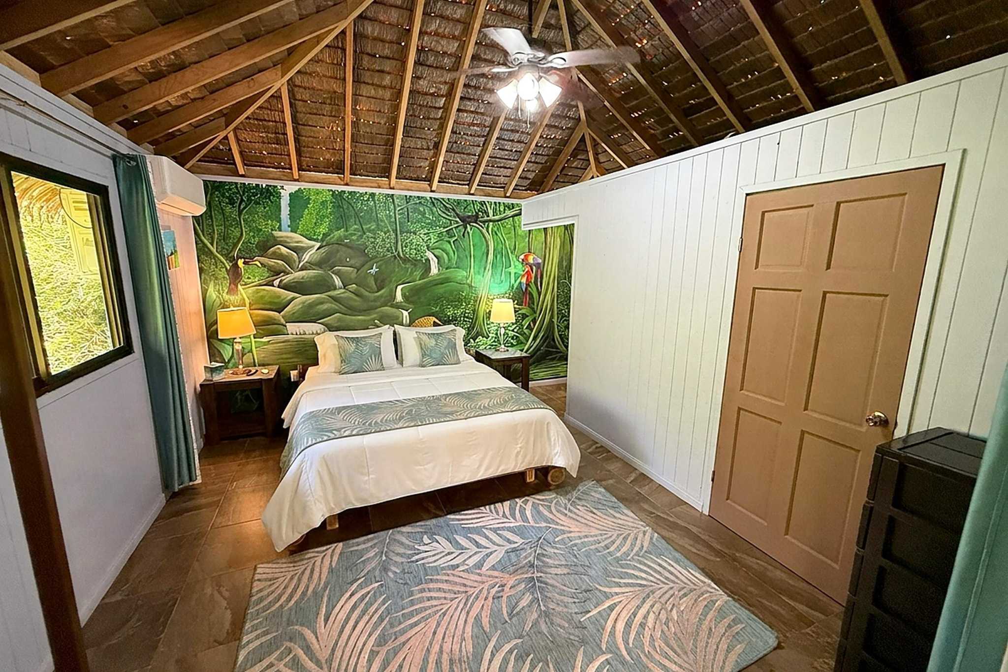 65486-18 Jungle Sanctuary bedroom with thatched ceiling and painted jungle mural in Ojochal, Costa Rica