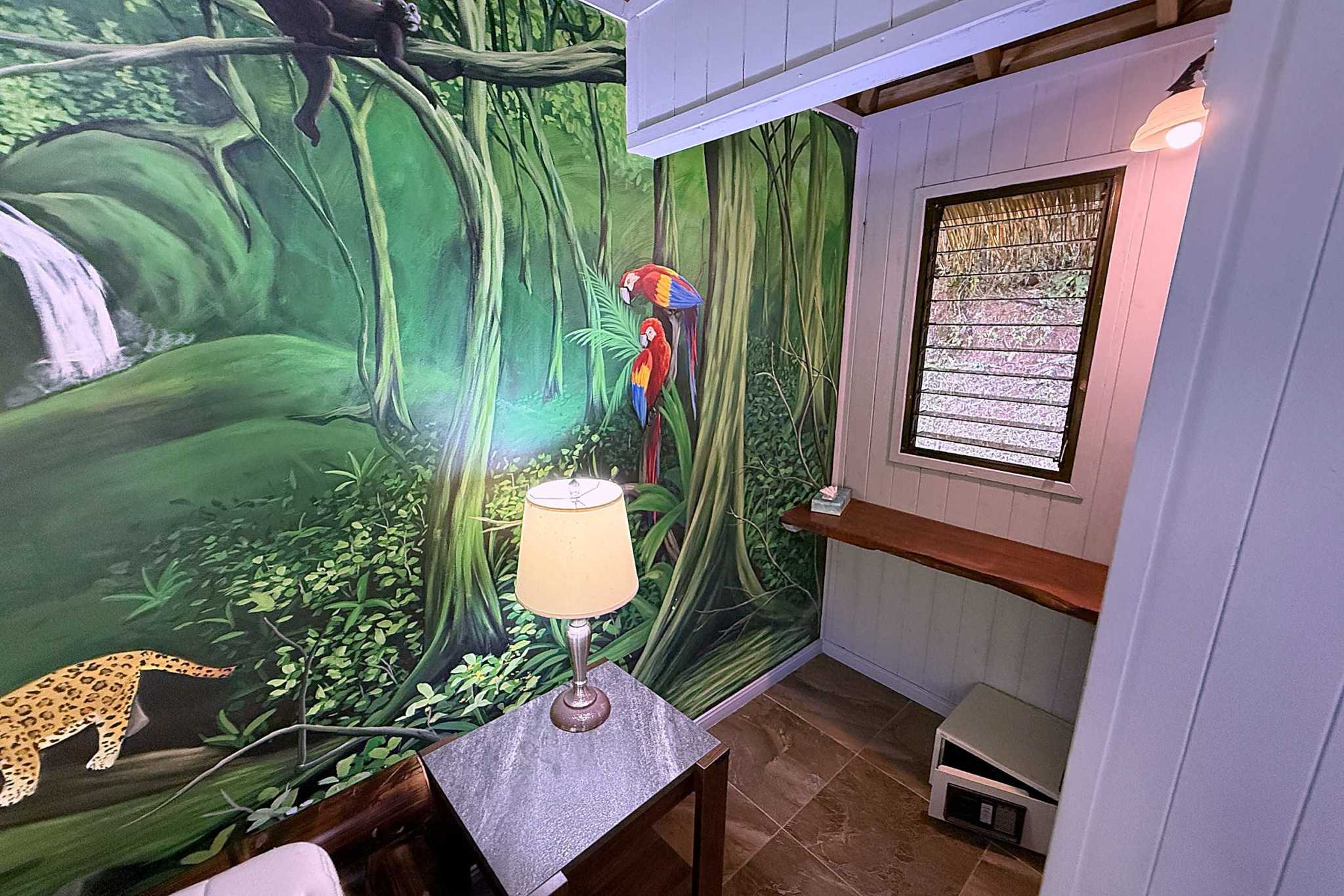 65486-21 Jungle Sanctuary hallway with painted jungle mural, macaws, lamp and window in Ojochal, Costa Rica