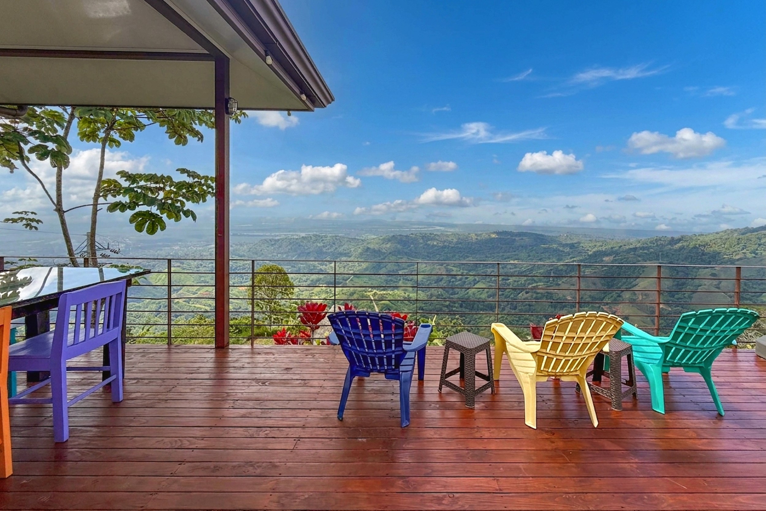 Ocean-View 3-Bedroom Home deck with colorful chairs and views in Toucan Valley/Osa Mountain Village, Costa Rica