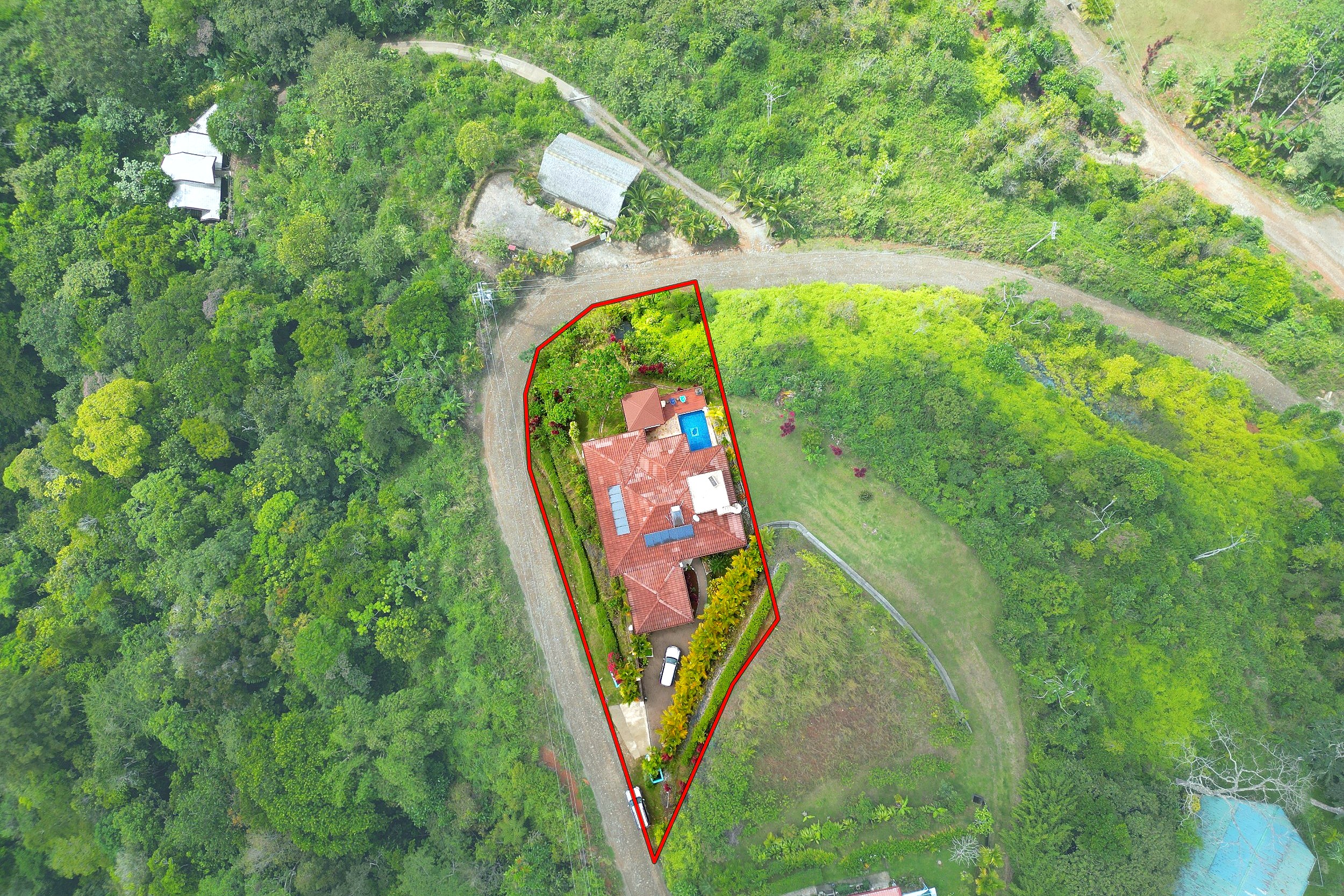 Aerial view of the outlined property, house, and pool surrounded by lush jungle in Toucan Valley, Costa Rica.