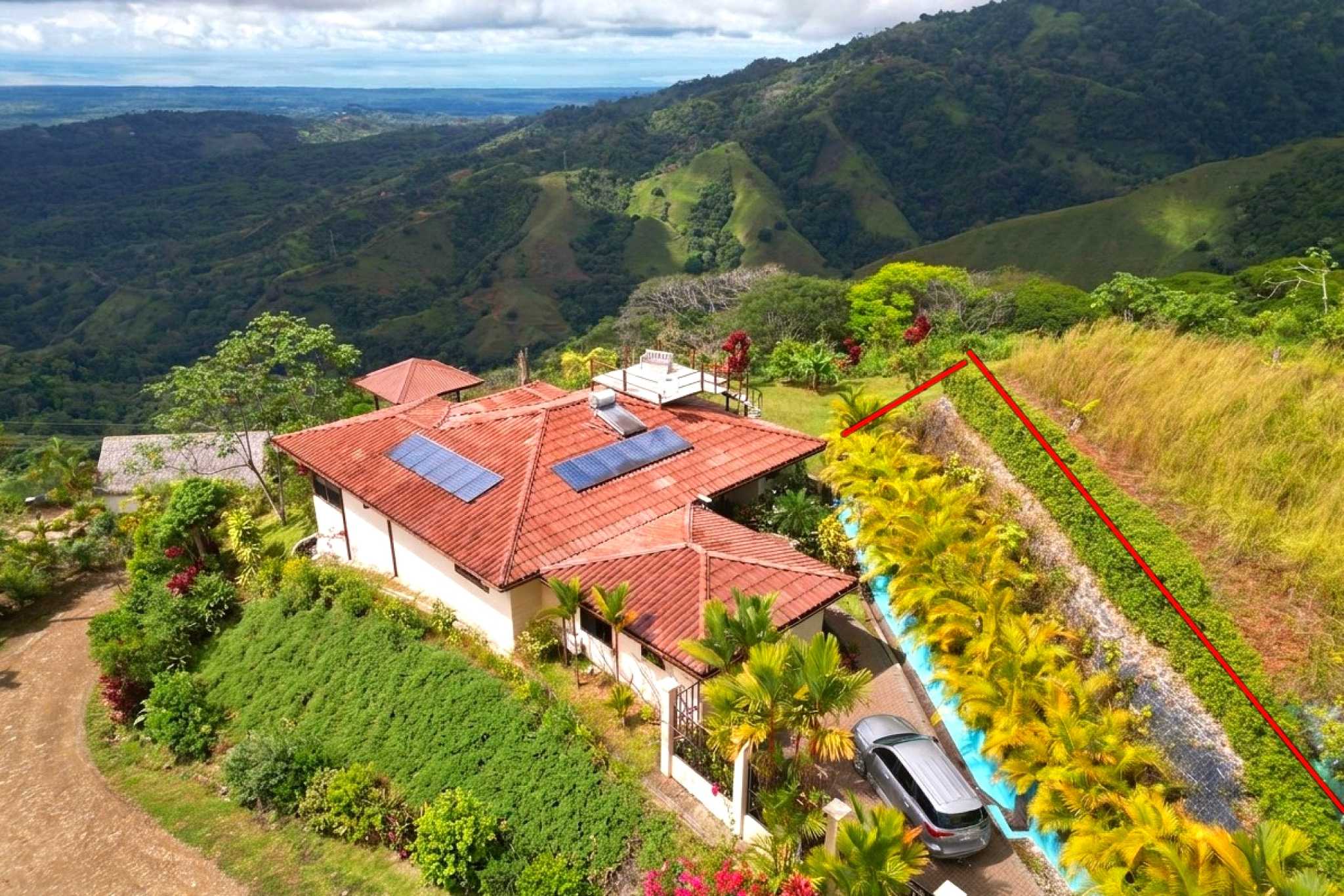 Hillside Villa Aerial View Aerial view of a hillside villa with solar panels and mountain views in Toucan Valley, Costa Rica.