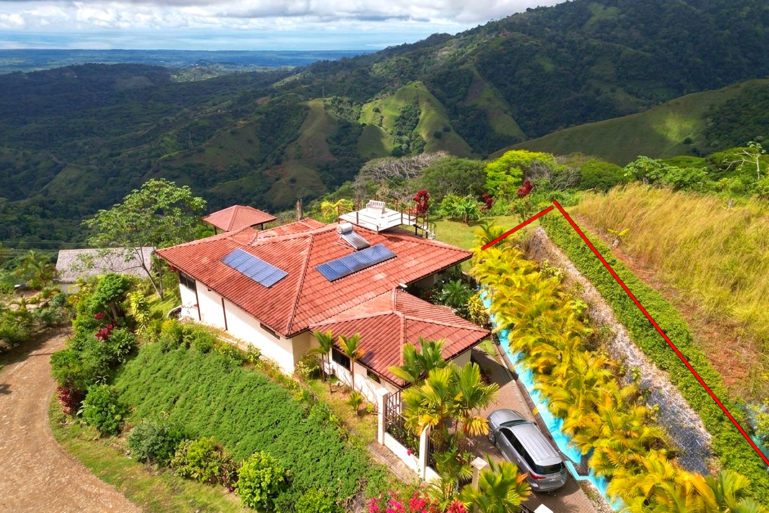 Aerial view of a hillside villa with solar panels and mountain views in Toucan Valley, Costa Rica.
