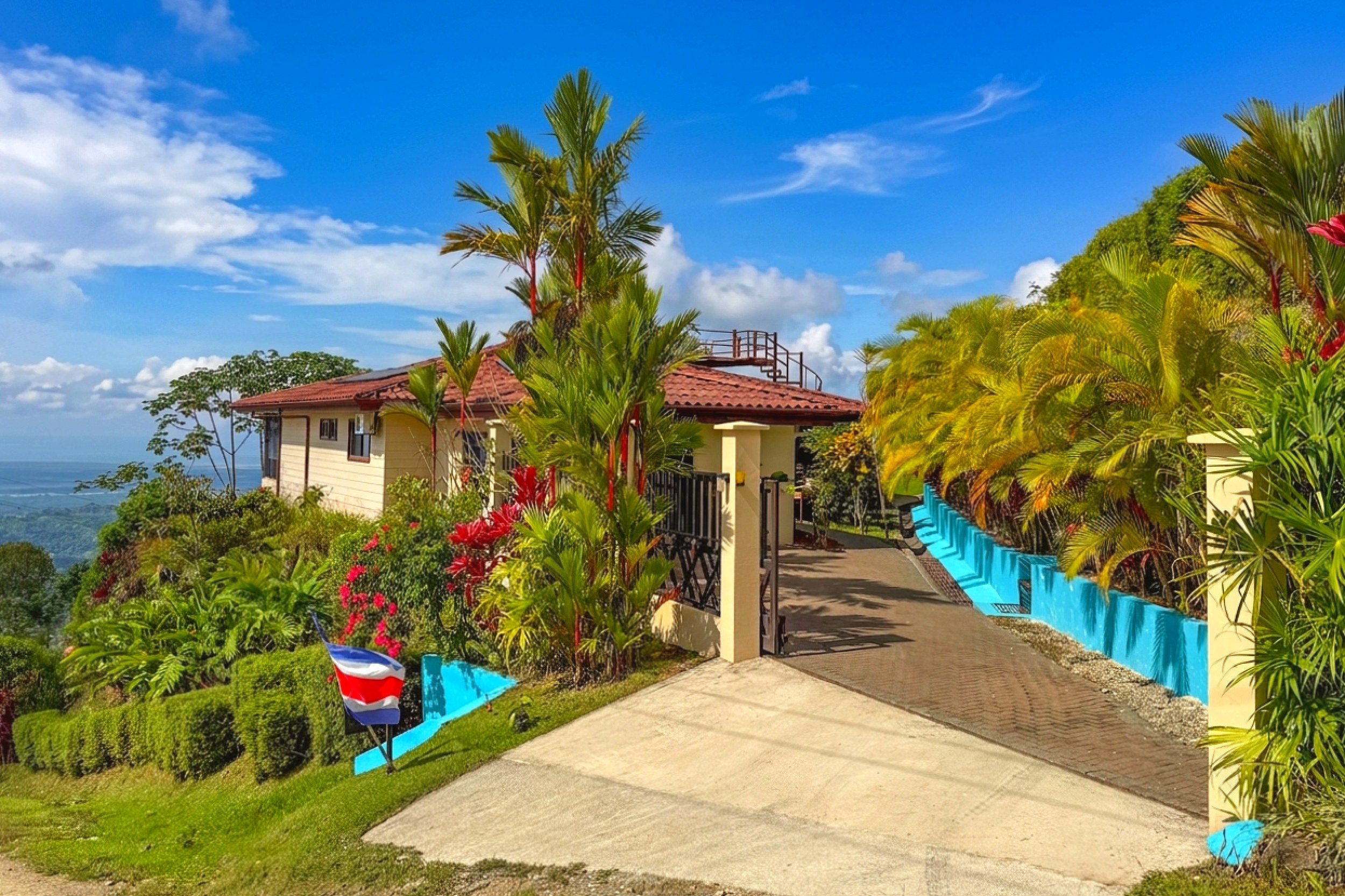 Gated driveway and lush tropical gardens surround the ocean-view home in Toucan Valley, Costa Rica.