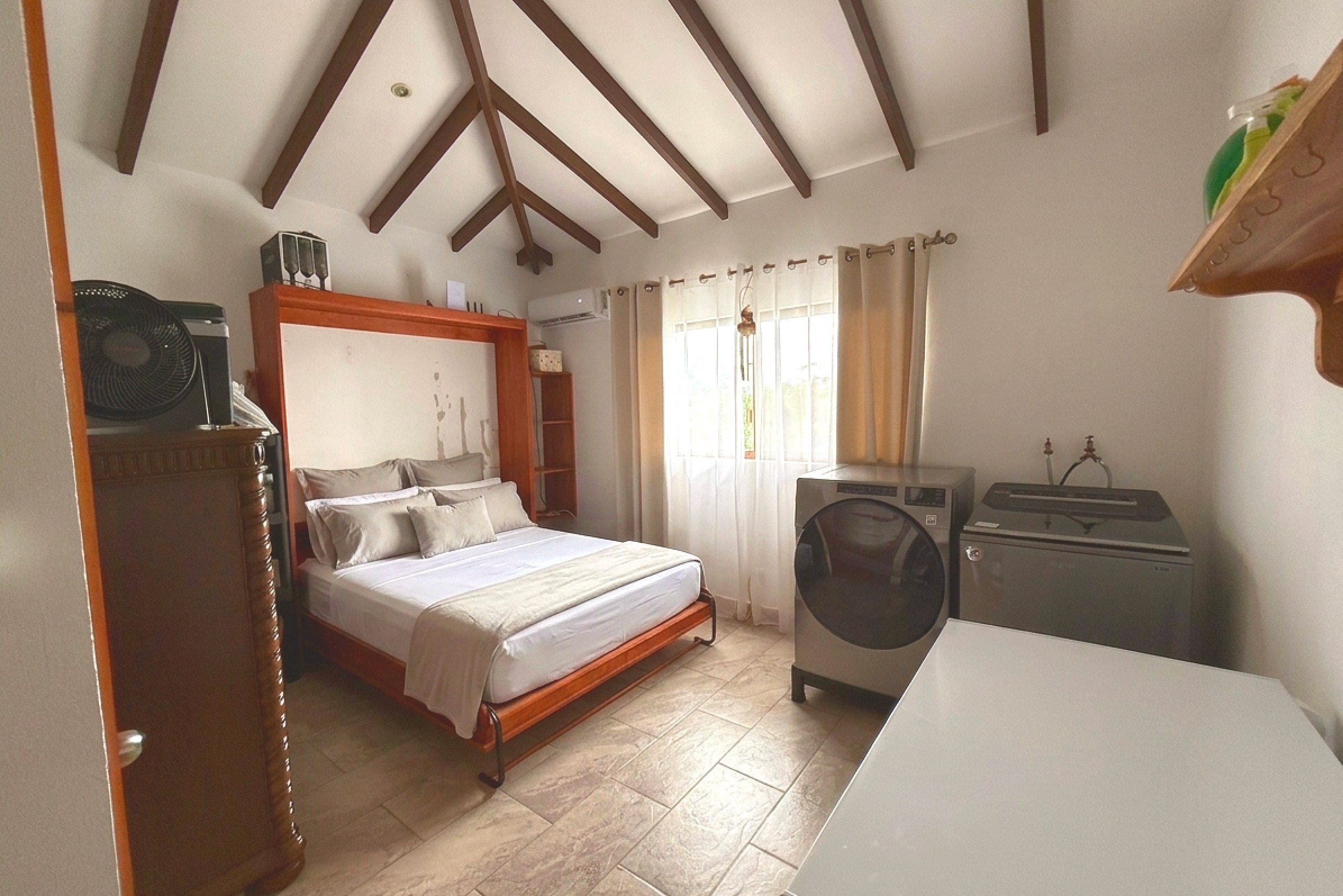 Ocean-View 3-Bedroom Home guest bedroom with bed and laundry in Toucan Valley/Osa Mountain Village, Costa Rica