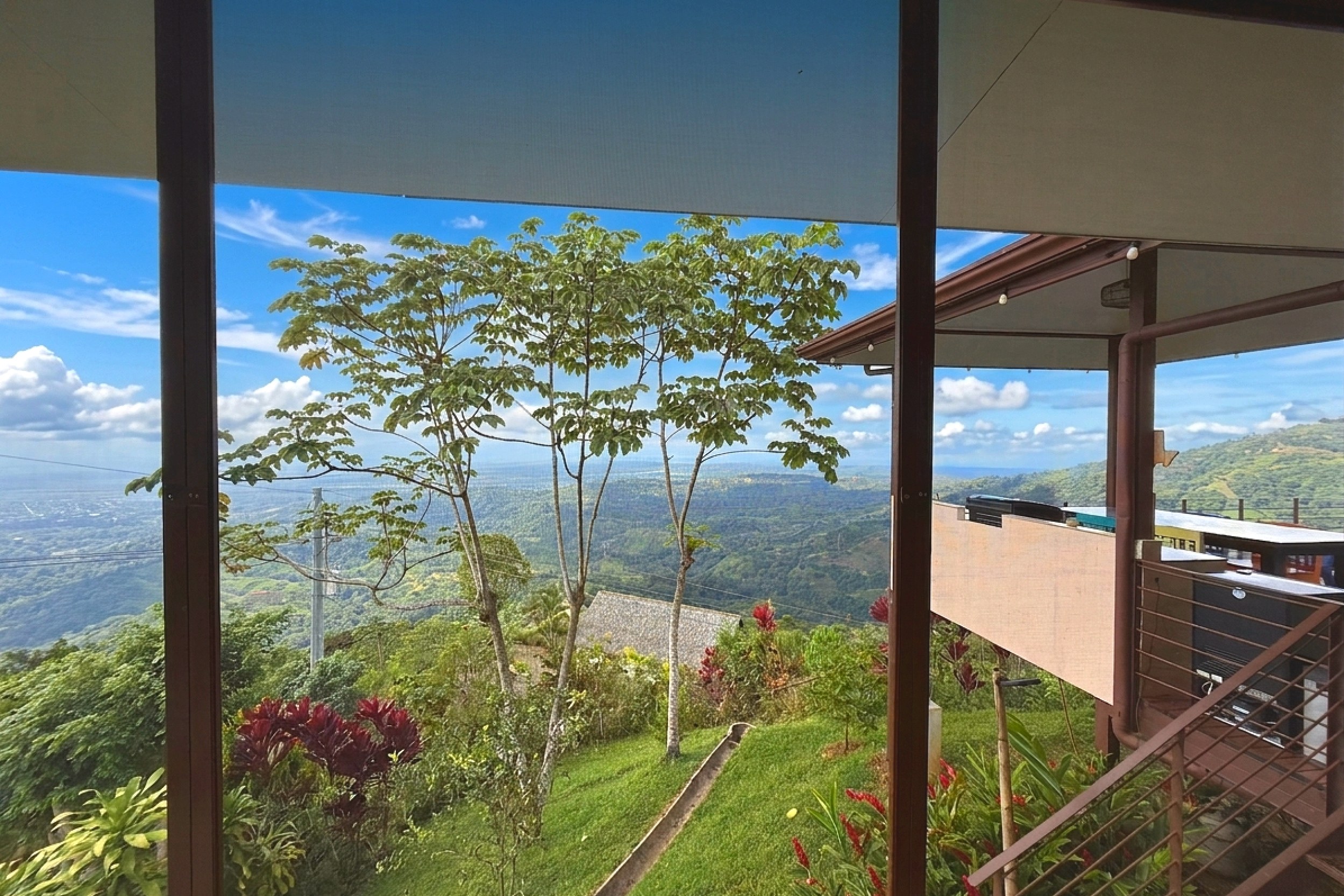 Panoramic mountain and ocean views from a covered balcony in Toucan Valley, Costa Rica.