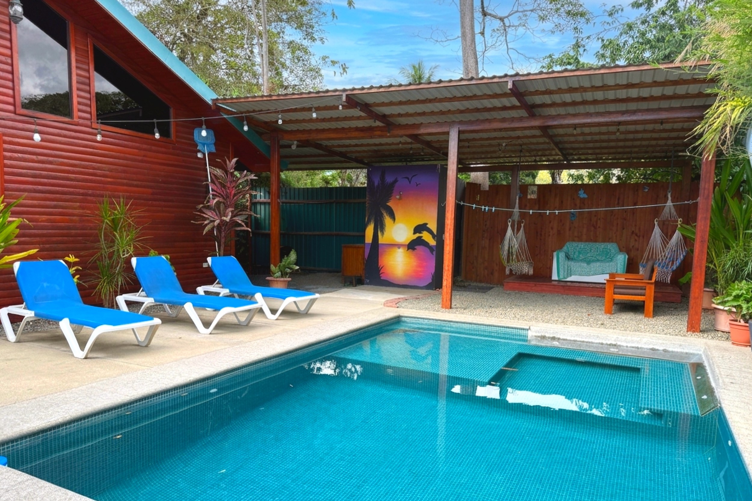 Pool & Covered Patio Unique Income Producing Home pool with blue loungers and covered patio in Bahia, Costa Rica