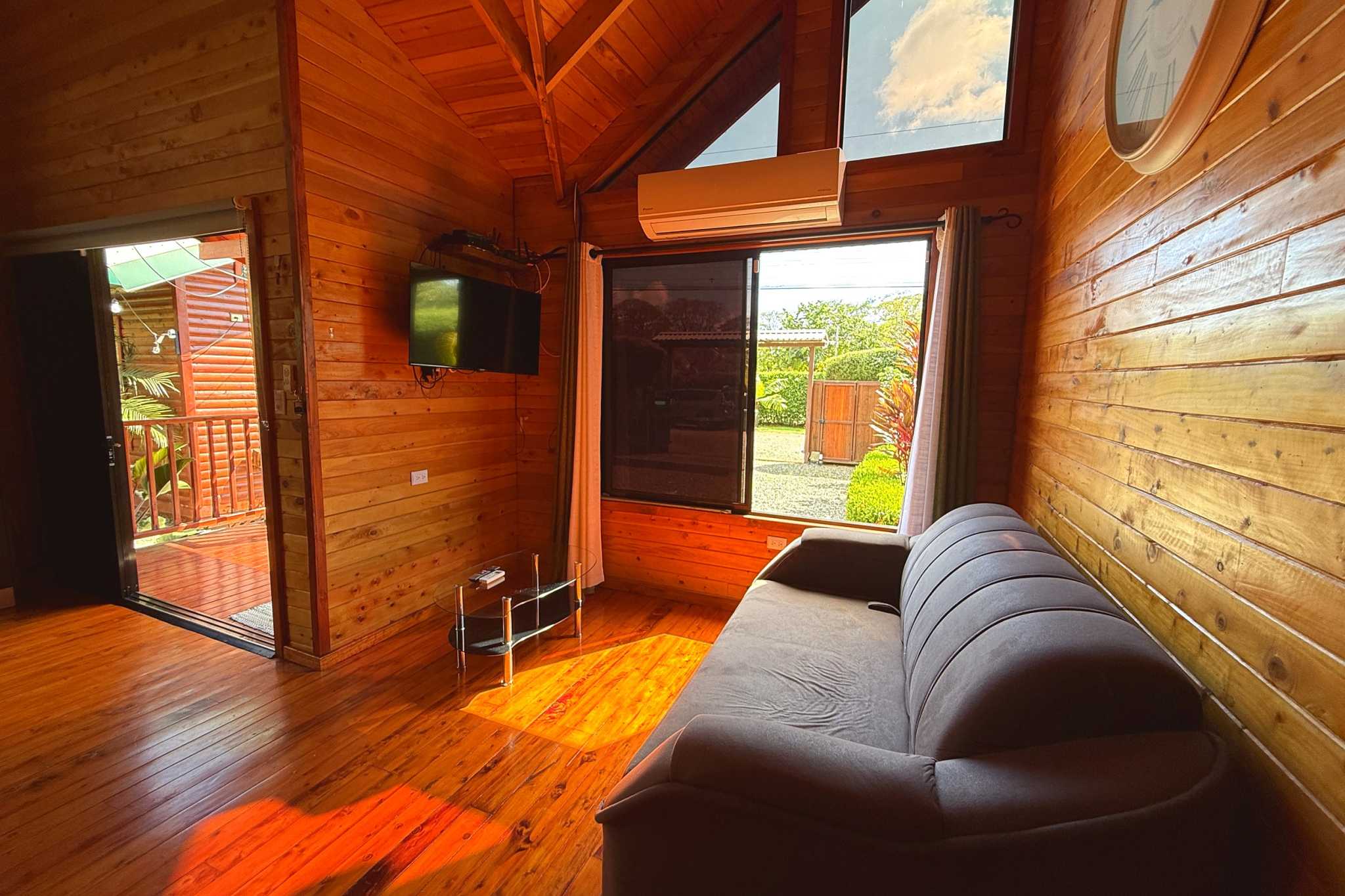 Wood-Paneled Living Room Unique Income Producing Home wood-paneled living room with sofa in Bahia, Costa Rica.