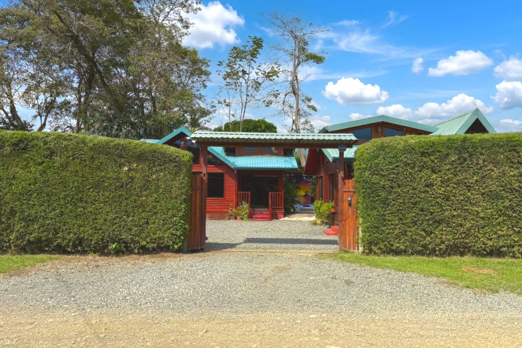 Gated Entrance & Driveway Unique Income Producing Home gated gravel driveway and green hedges in Bahia, Costa Rica