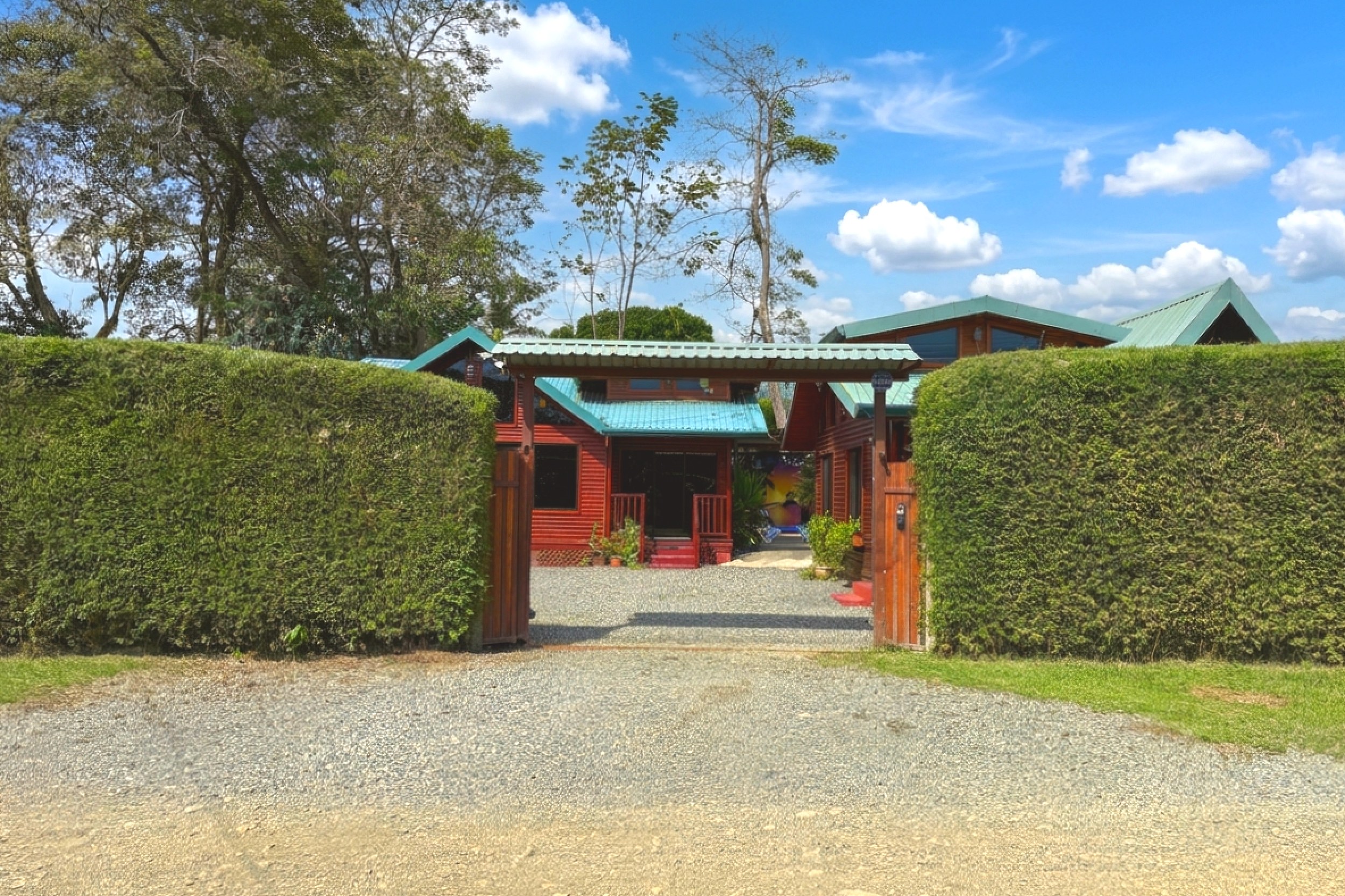 Gated Entrance & Driveway Unique Income Producing Home gated gravel driveway and green hedges in Bahia, Costa Rica