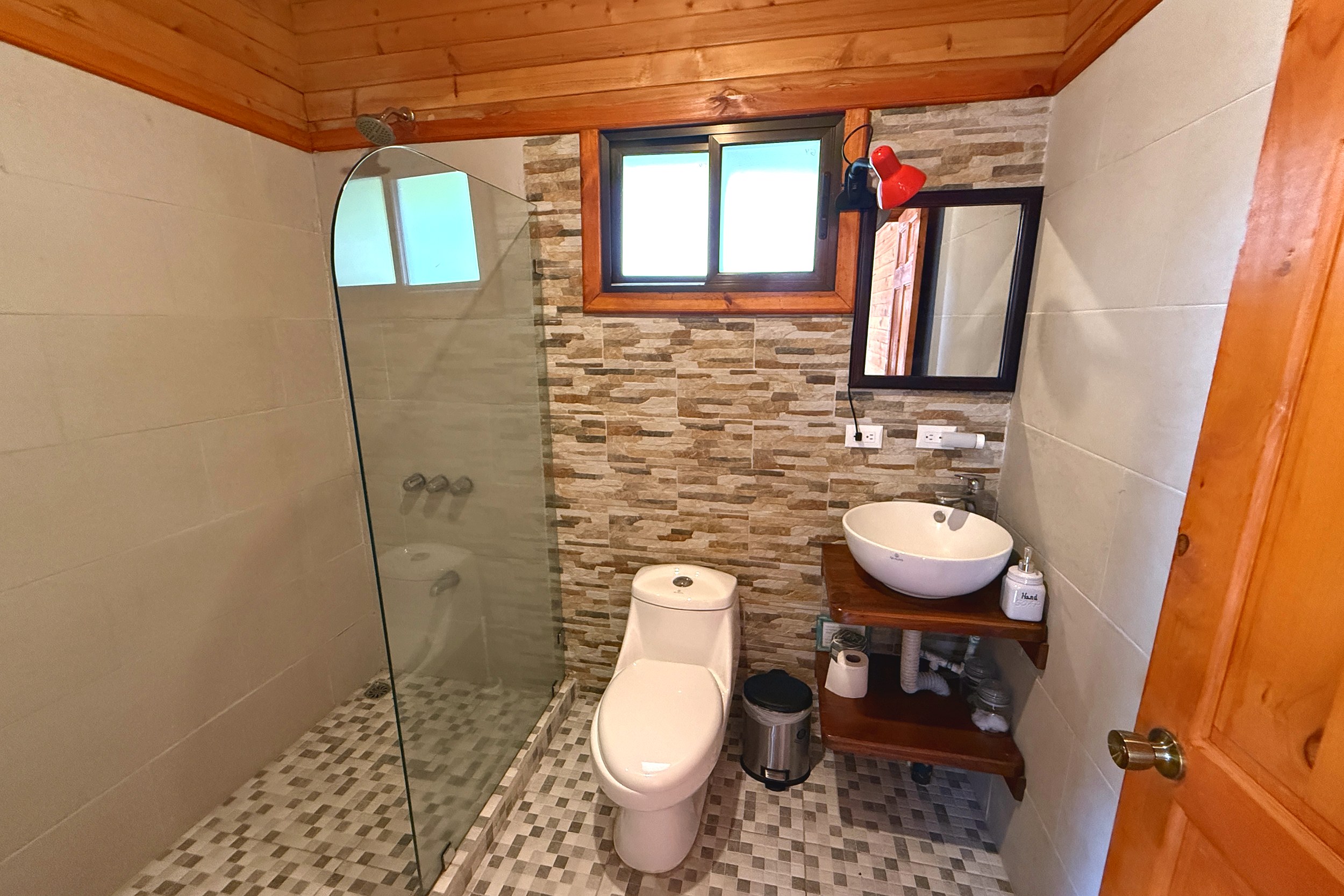 Modern Tiled Bathroom Income Producing Home bathroom with glass shower and stone accent wall in Bahia, Costa Rica