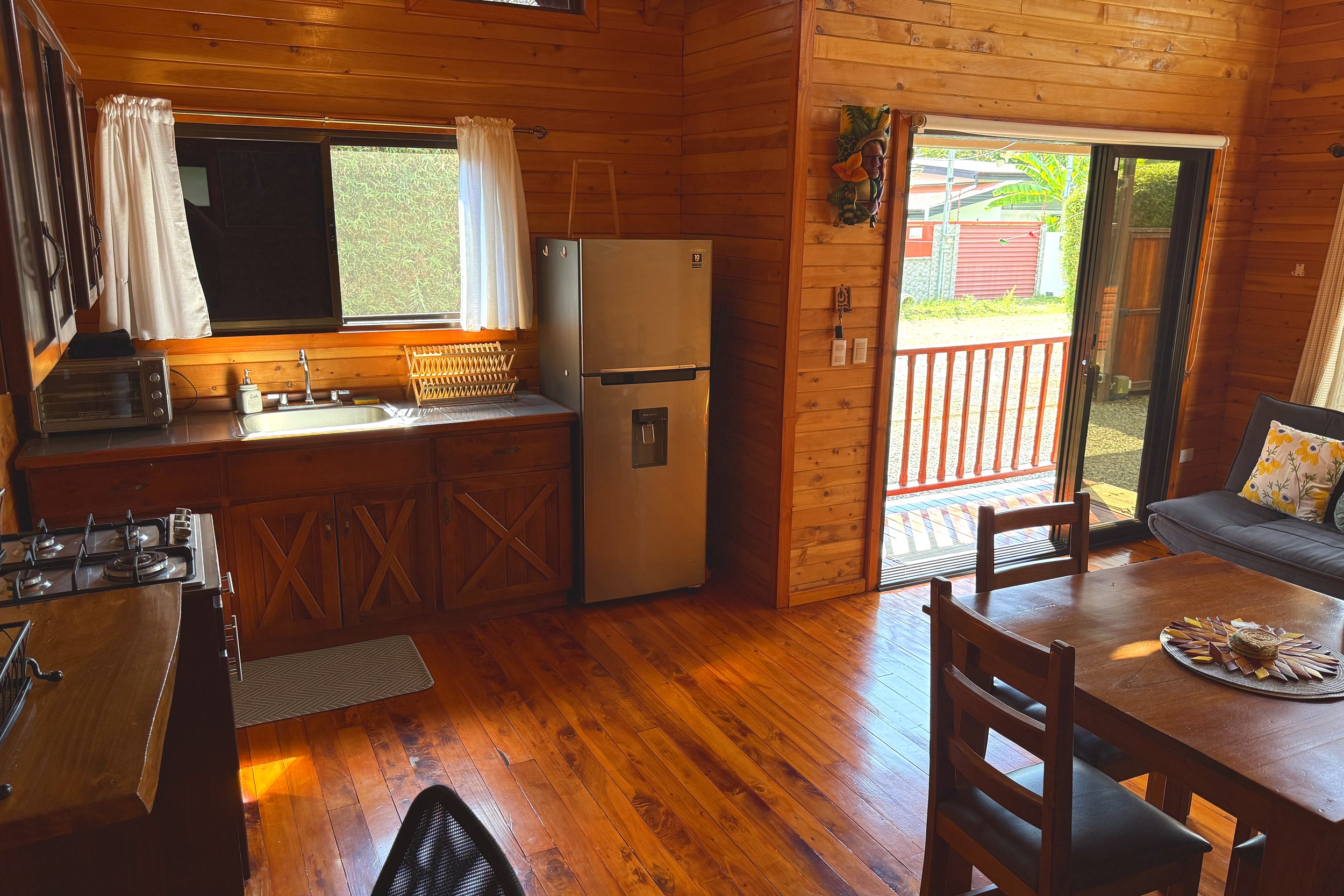 Cabin Kitchen & Dining Income Producing Cabin Home wooden kitchen with steel fridge and dining table in Bahia, Costa Rica