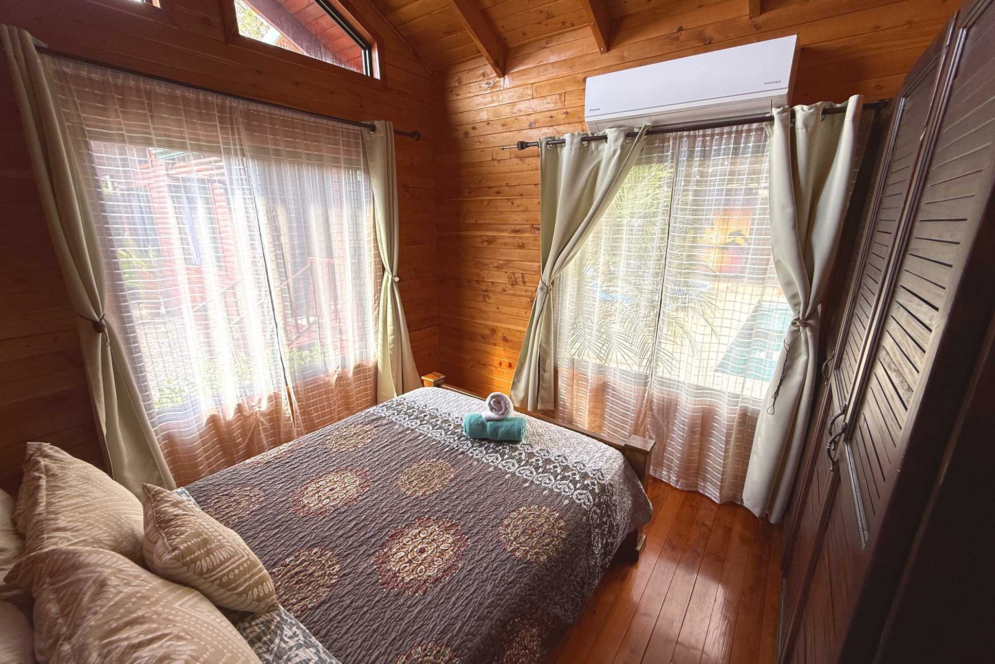 Cozy Cabin Bedroom Unique Income Producing Home wooden cabin bedroom with bed in Bahia, Costa Rica