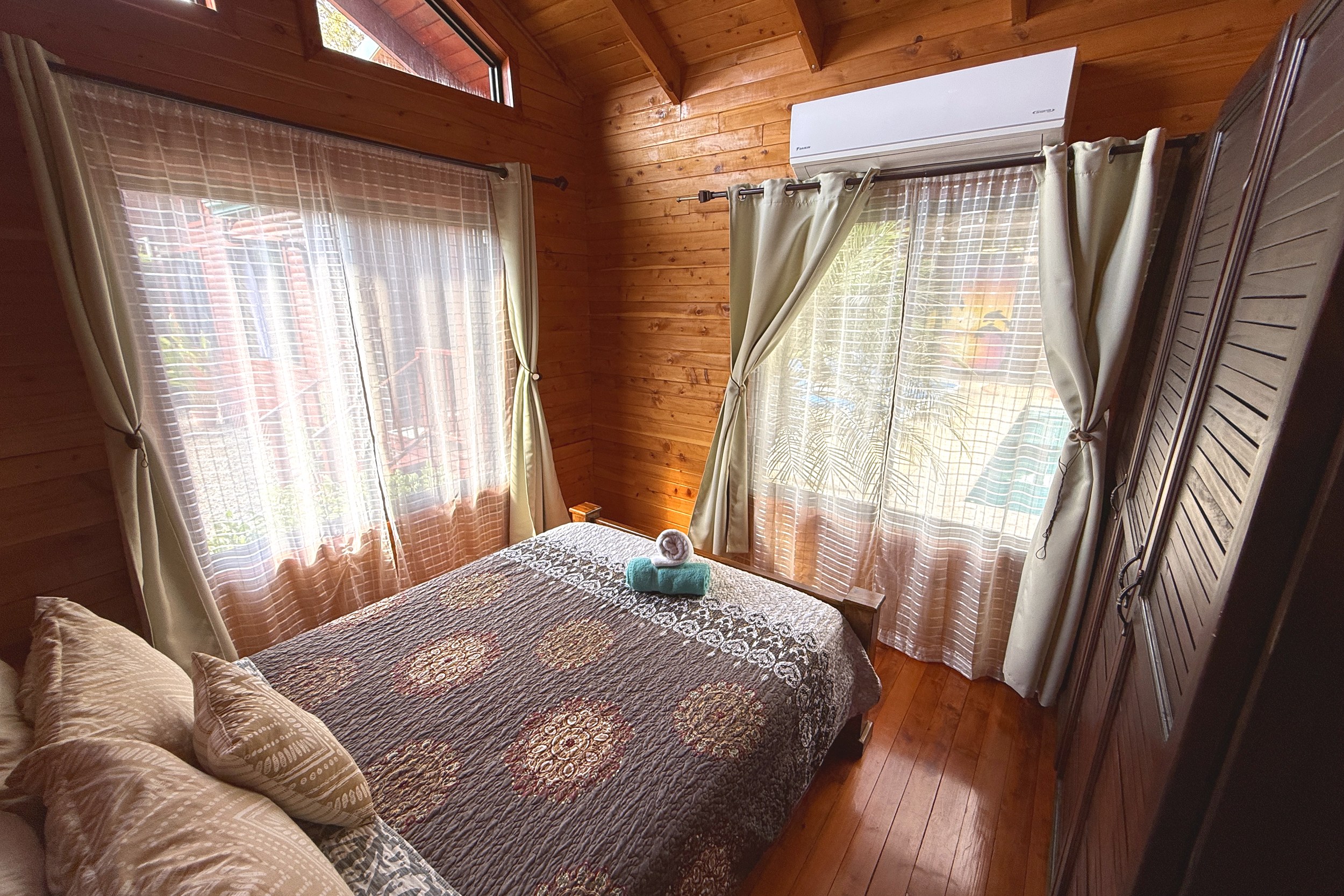Cozy Cabin Bedroom Unique Income Producing Home wooden cabin bedroom with bed in Bahia, Costa Rica