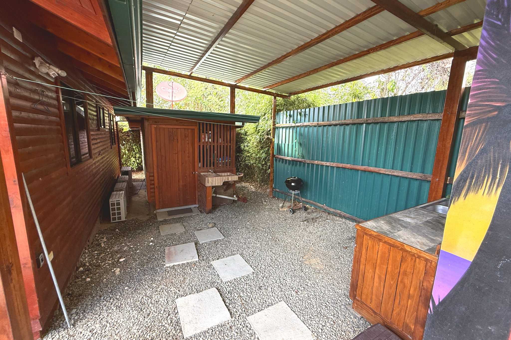 Covered Outdoor BBQ Area Unique Income Producing Home covered gravel side yard with BBQ and sink in Bahia, Costa Rica.