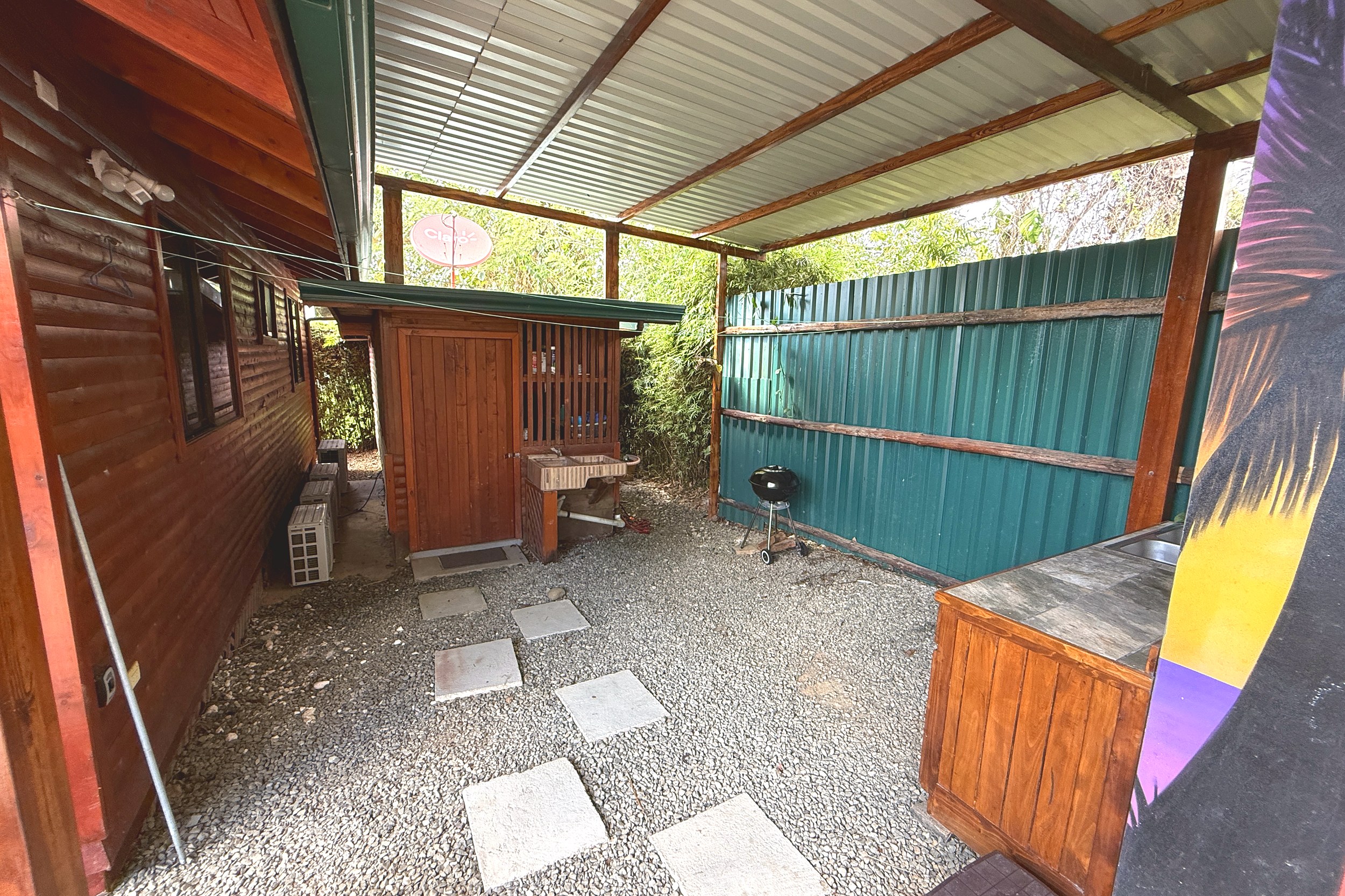 Covered Outdoor BBQ Area Unique Income Producing Home covered gravel side yard with BBQ and sink in Bahia, Costa Rica.