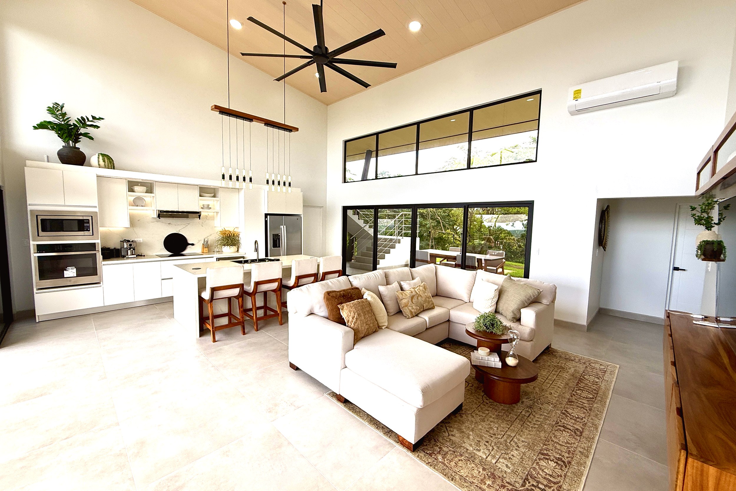 Modern Luxury 4-Bedroom Home living room with sectional sofa and kitchen in Chontales, Costa Rica