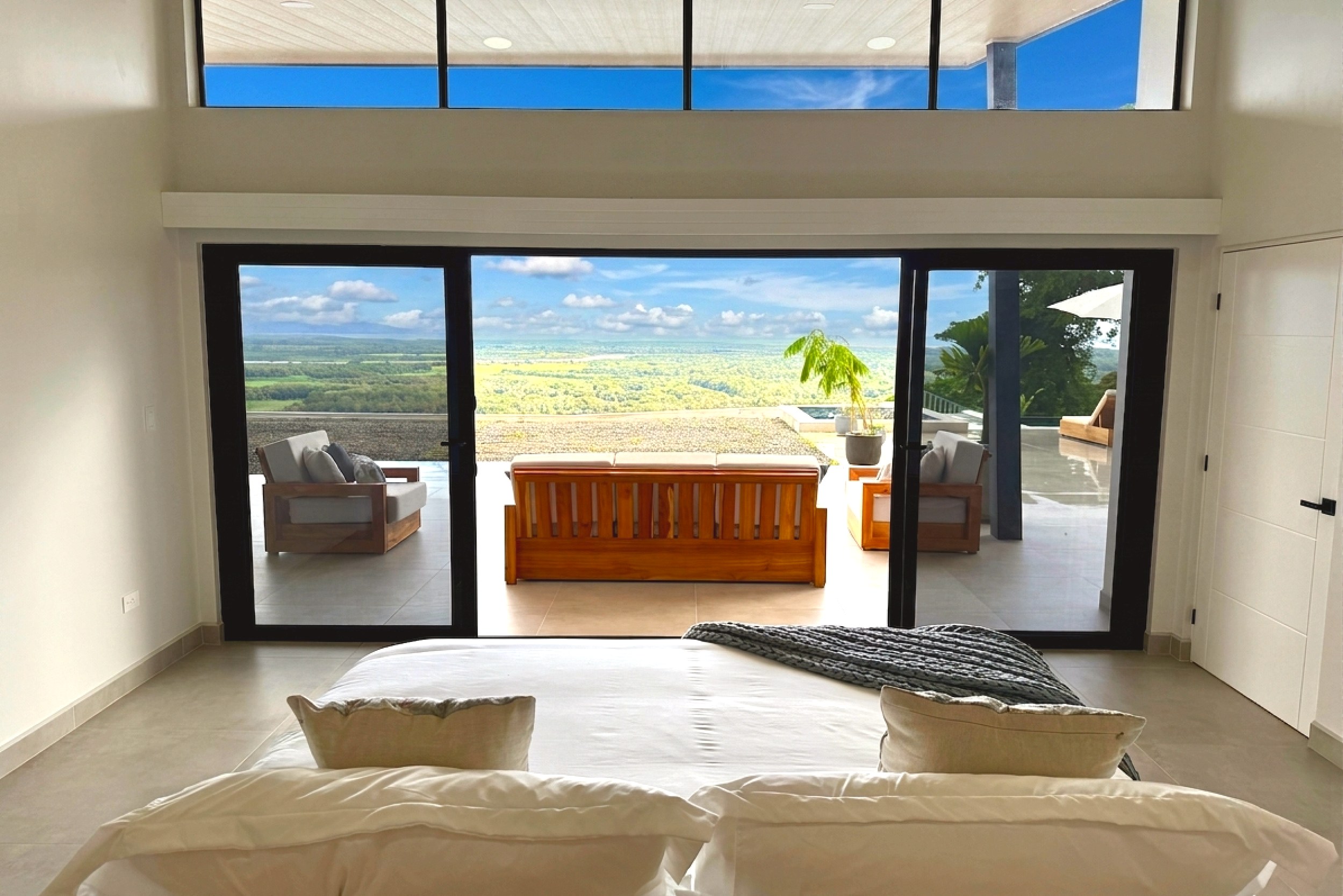 Modern Luxury 4-Bedroom Home master bedroom looking out to patio in Chontales, Costa Rica.
