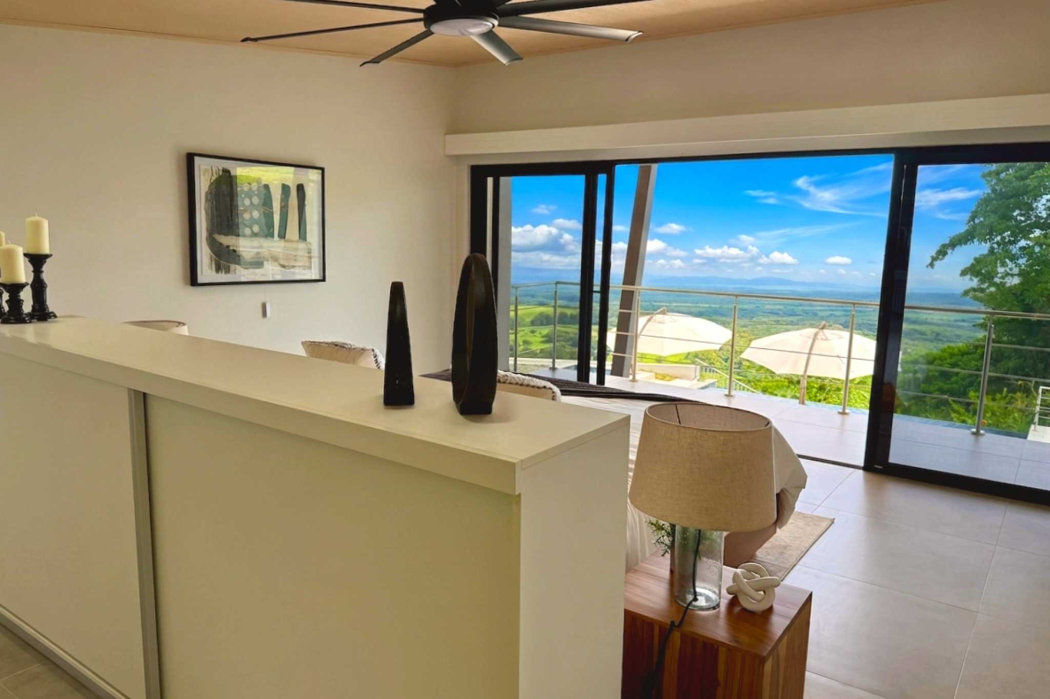Main Guest Bedroom Modern Luxury 4-Bedroom Home guest bedroom with scenic balcony views in Chontales, Costa Rica.