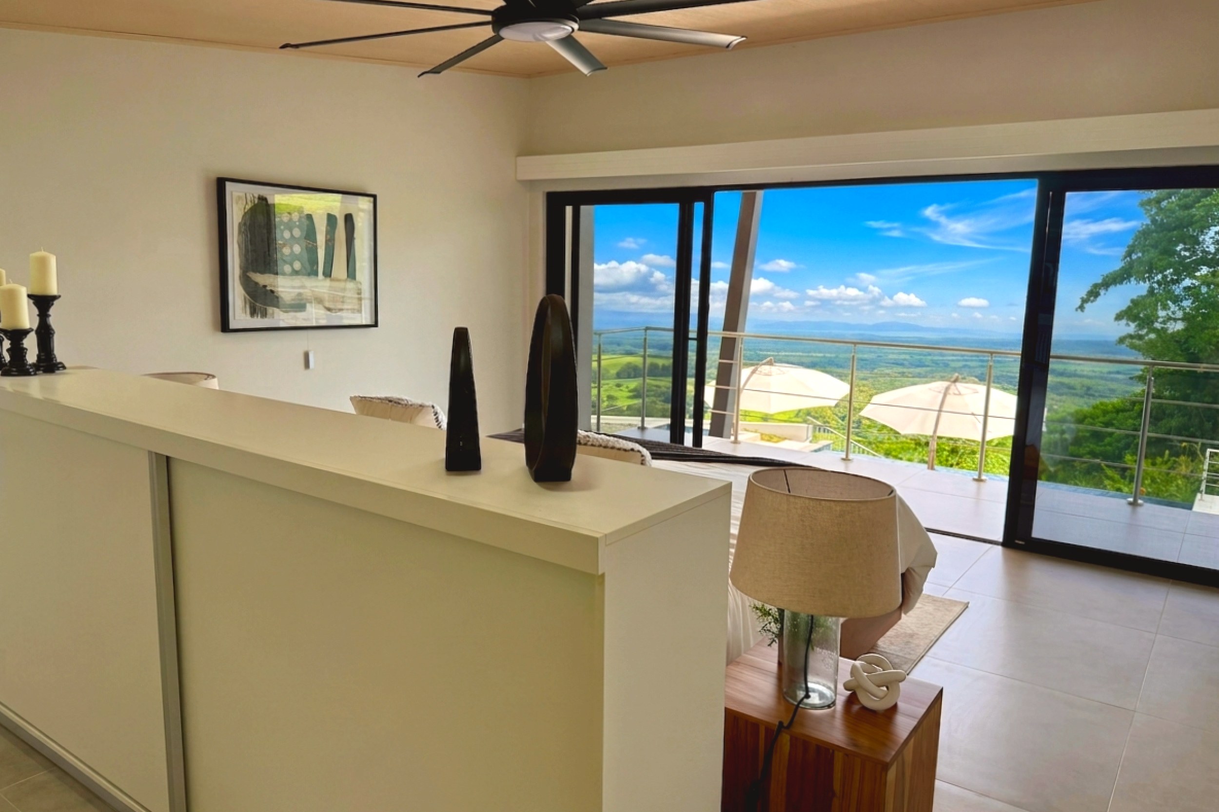 Modern Luxury 4-Bedroom Home guest bedroom with scenic balcony views in Chontales, Costa Rica.