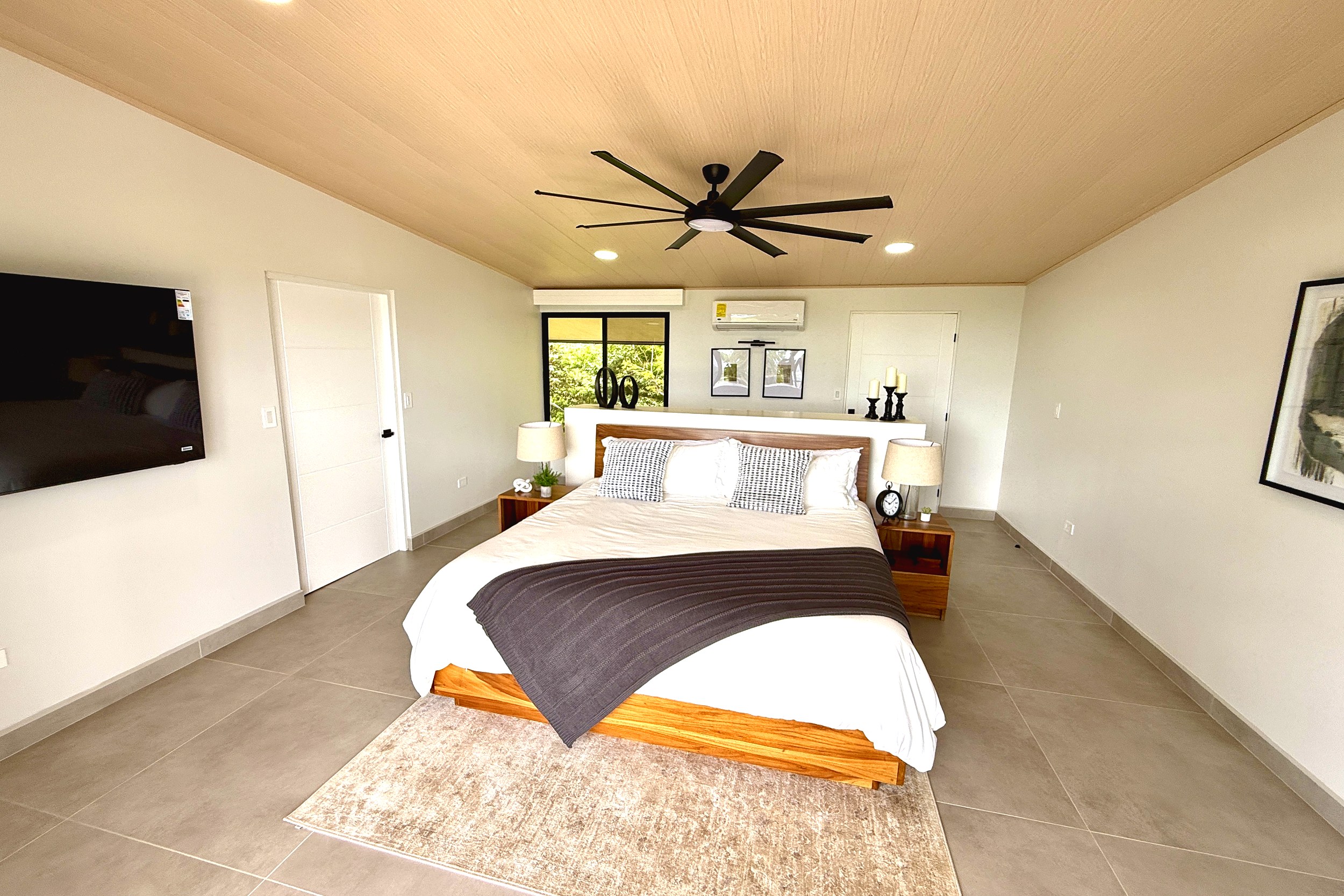 Modern Luxury Home guest bedroom with king bed and wood ceiling in Chontales, Costa Rica.